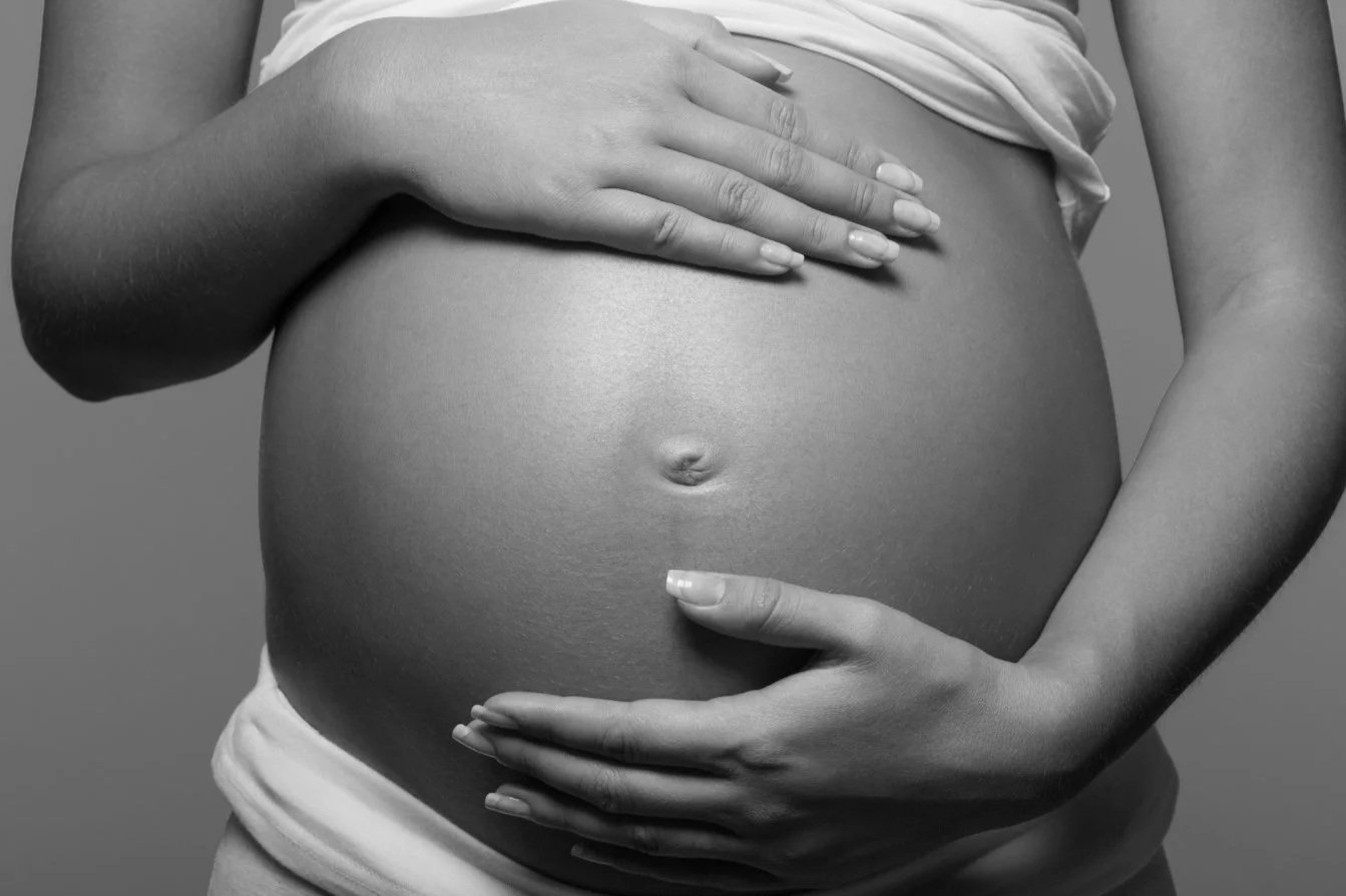 on voit deux mains de femme sur son ventre enceinte de 7 ou 8 mois afin d'imager le fait de prendre rdv afin de comprendre ses choix pour sa fin de grossesse