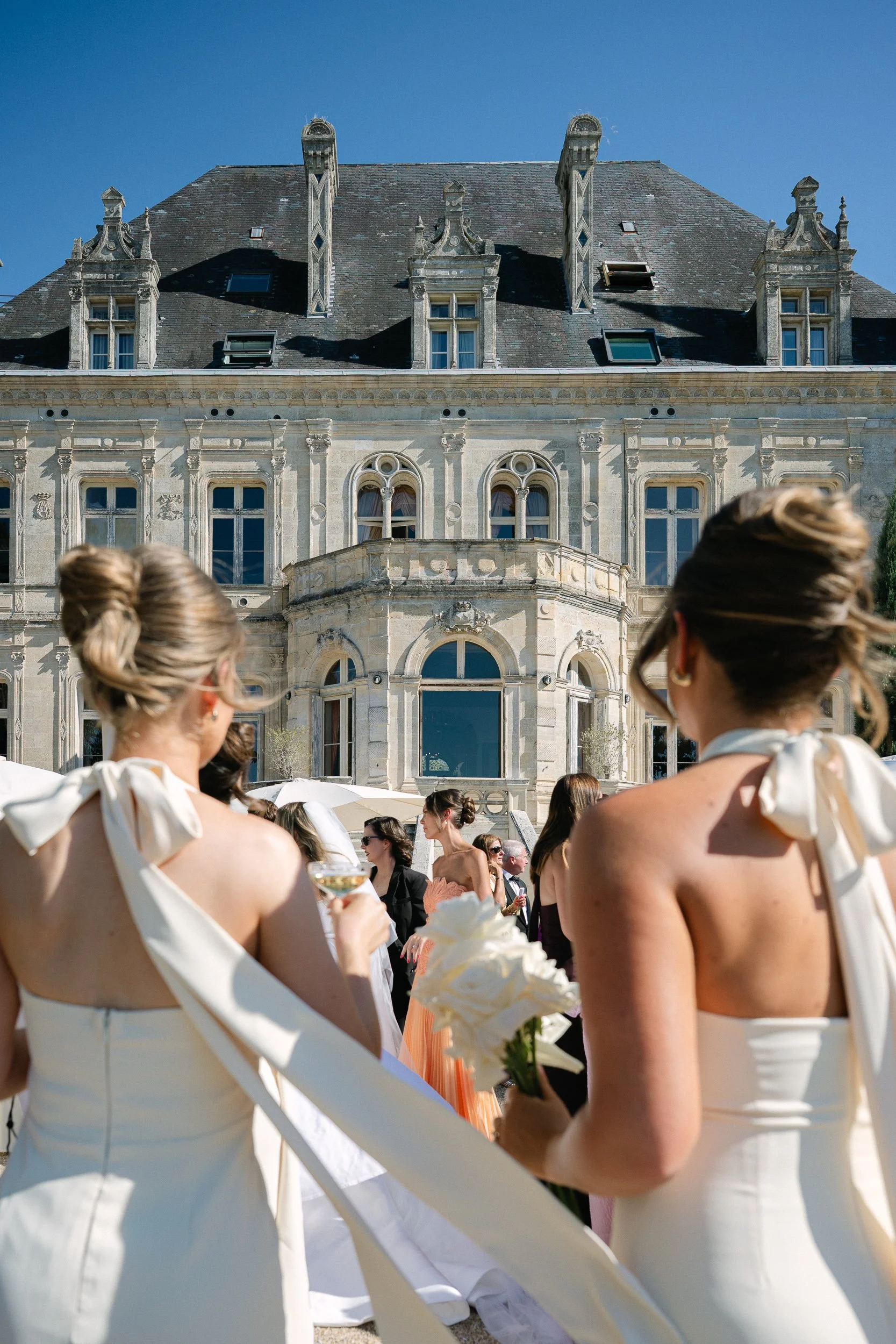 Guests watching the ceremony with the château facade behind them at Château de la Valouze