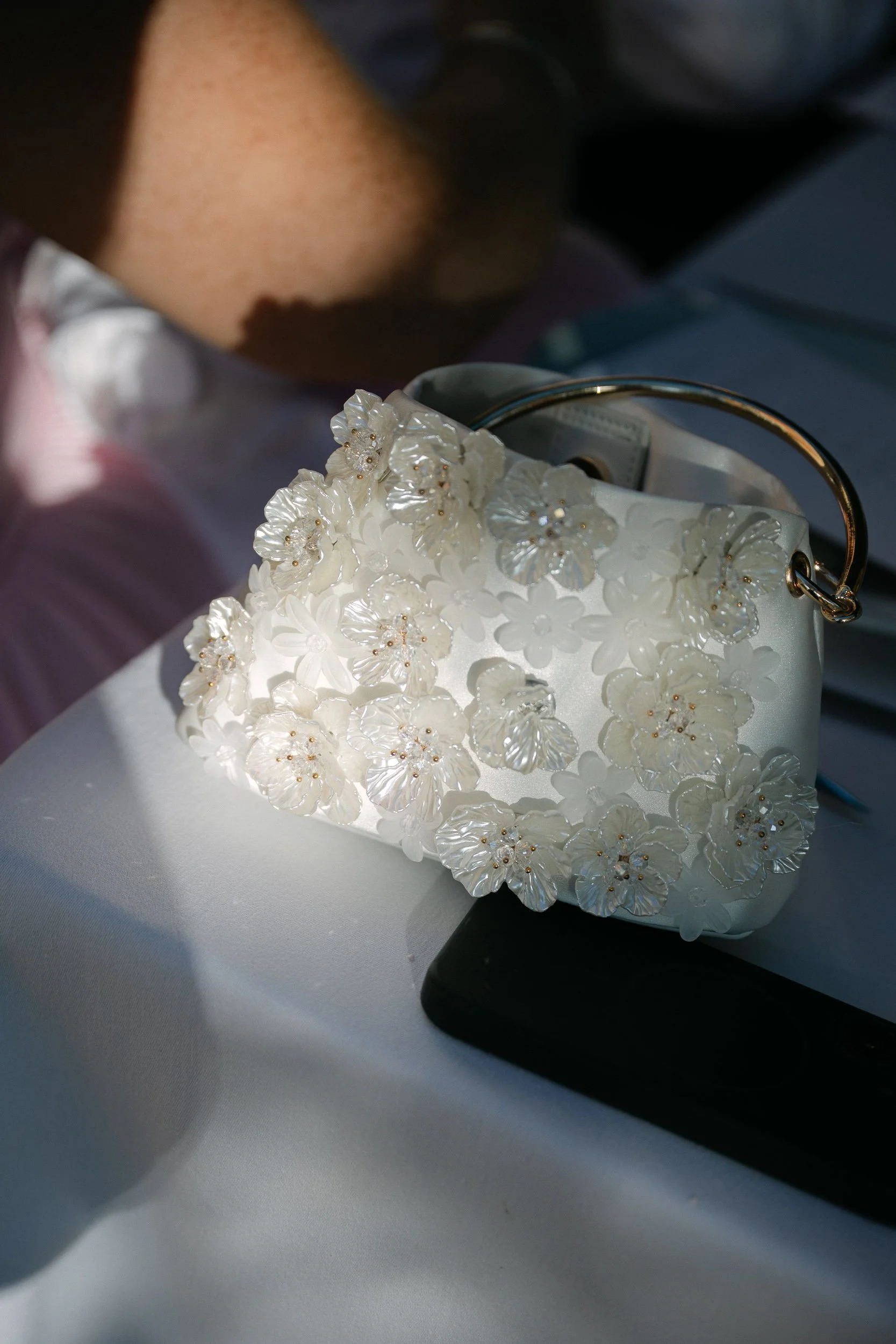 The bride's white floral handbag resting on a table at Château de la Valouze