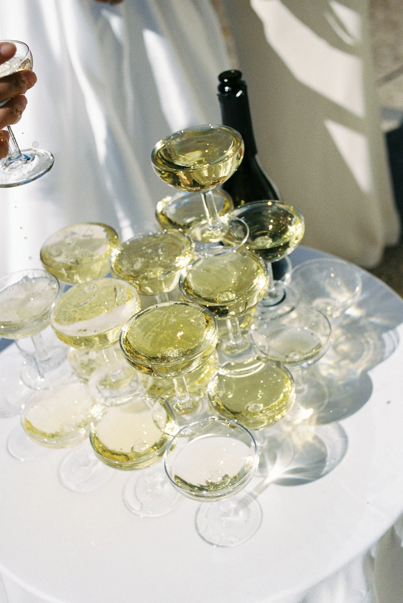 Coupe glasses stacked into a champagne tower in the sunshine at Château de la Valouze