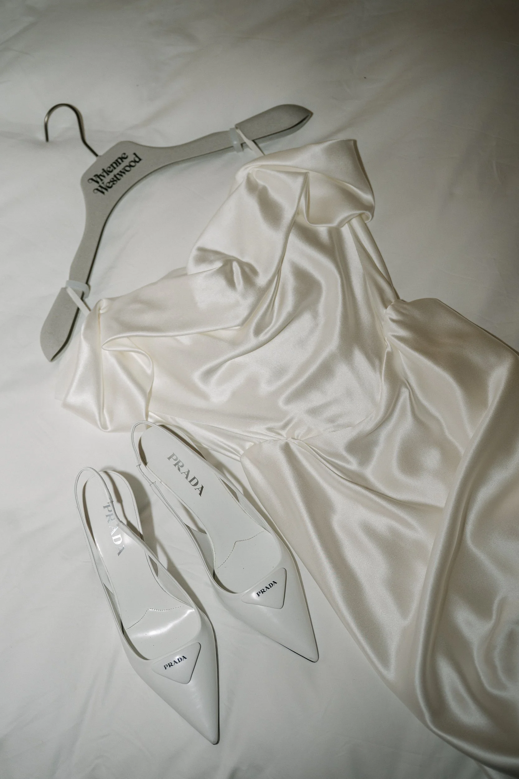 Vivienne Westwood wedding dress hanging beside a pair of Prada heels at the Sloane Hotel