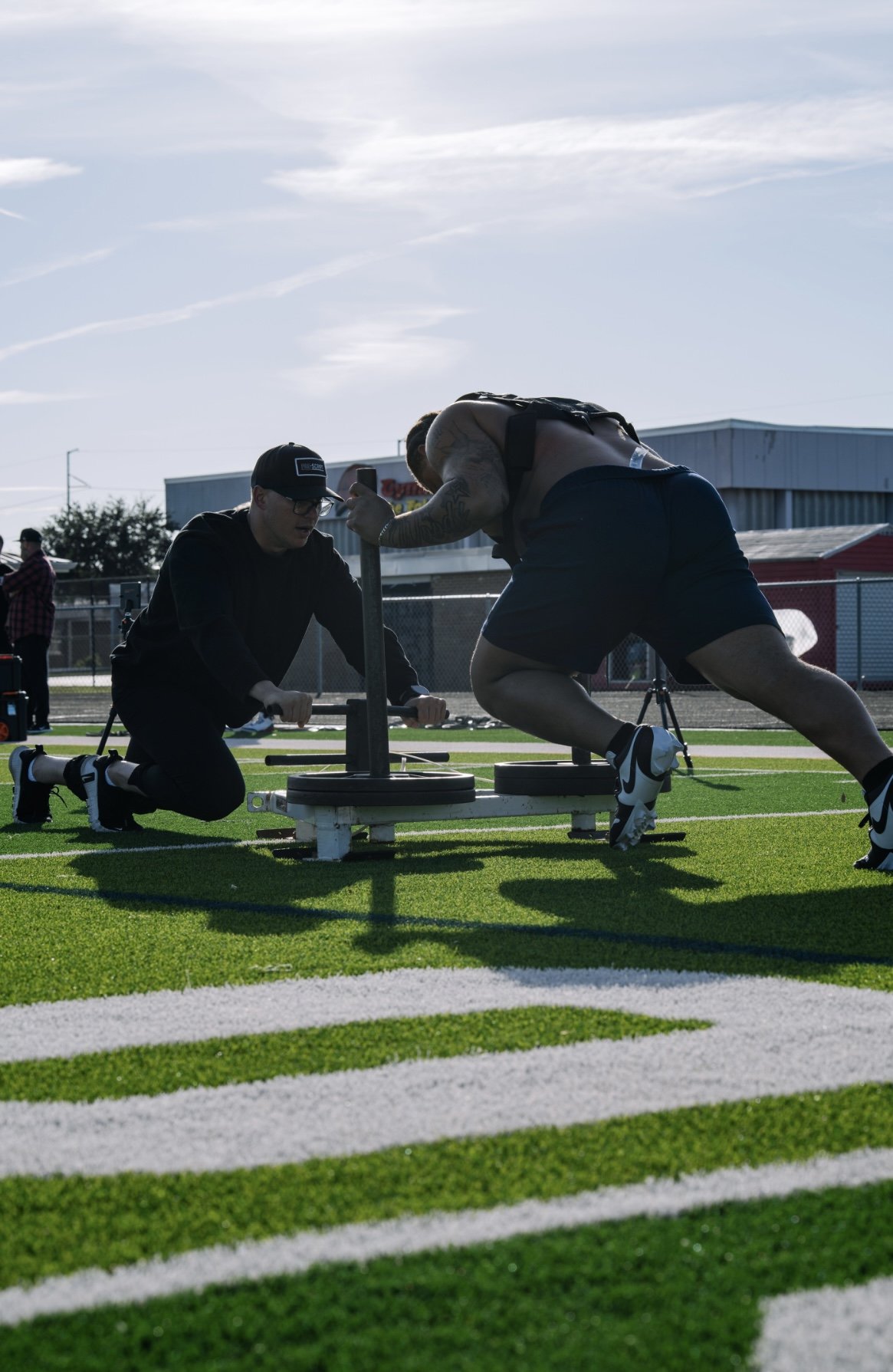 Anton Esterhuizen helping an athlete on the field during a workout