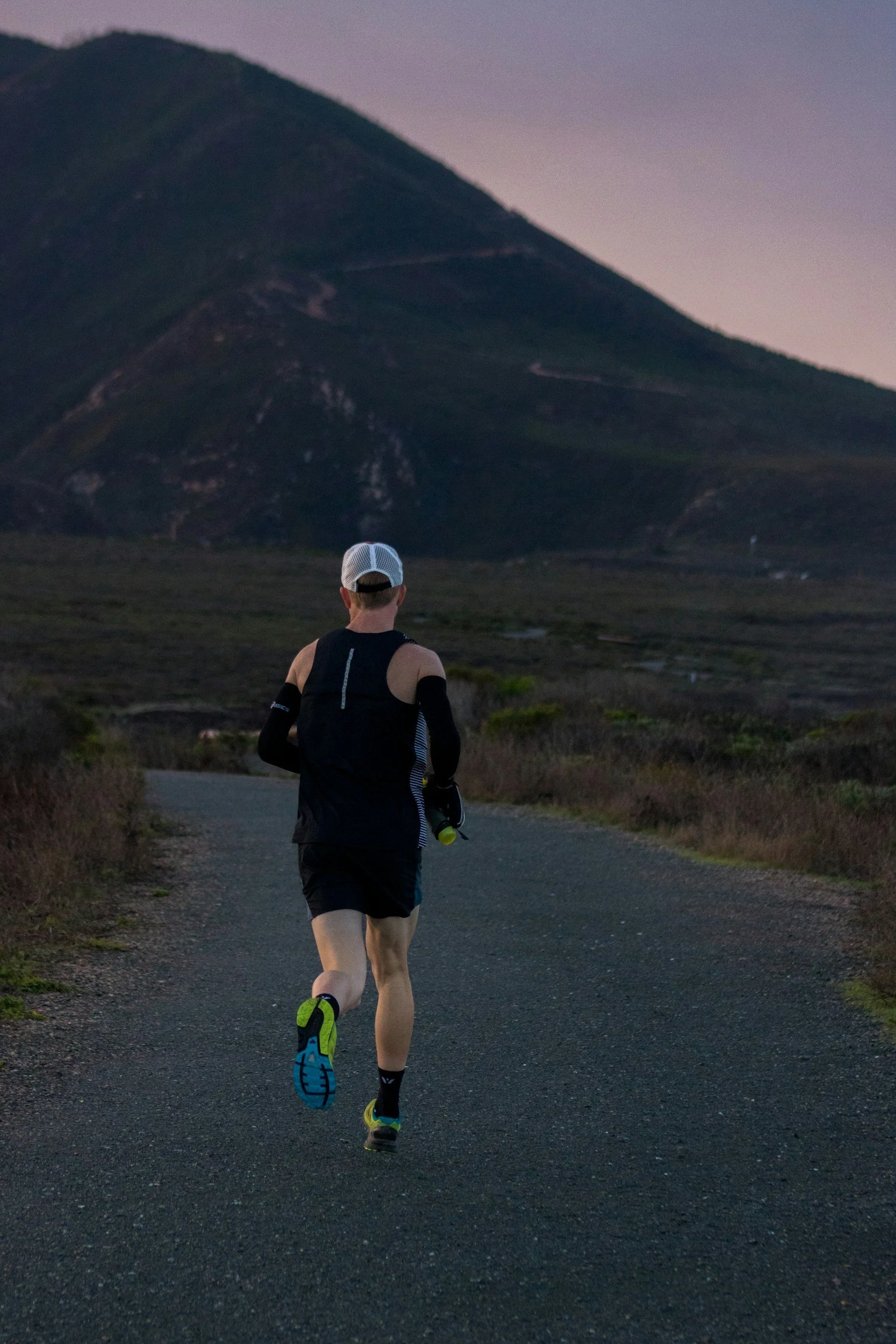 Athlete running on a paved road in the country side