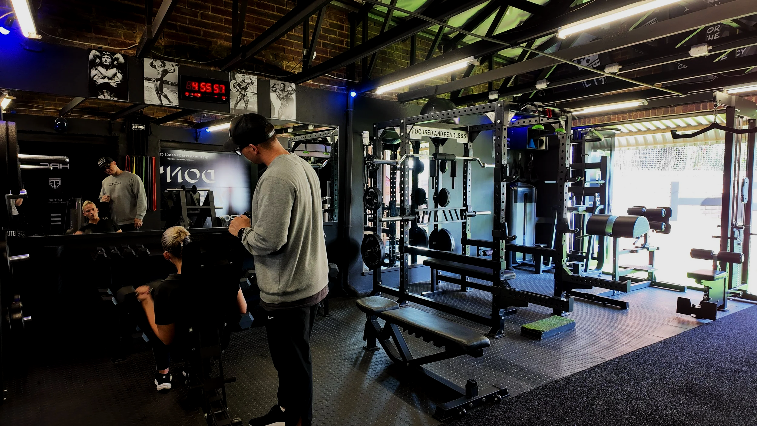 A client performing an overhead shoulder press with an HPC coach guiding her