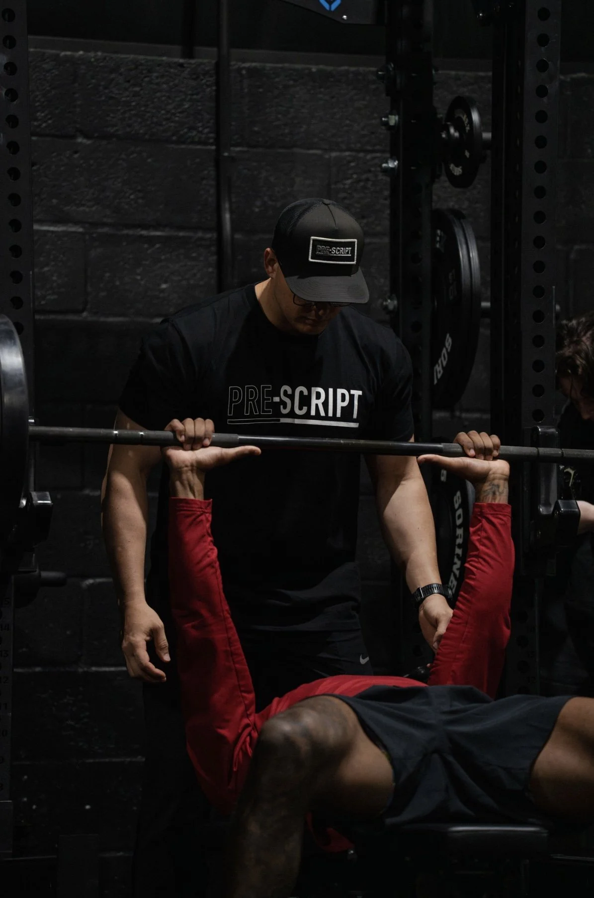 HPC Head coach spotting an athlete during a benchpress exercise