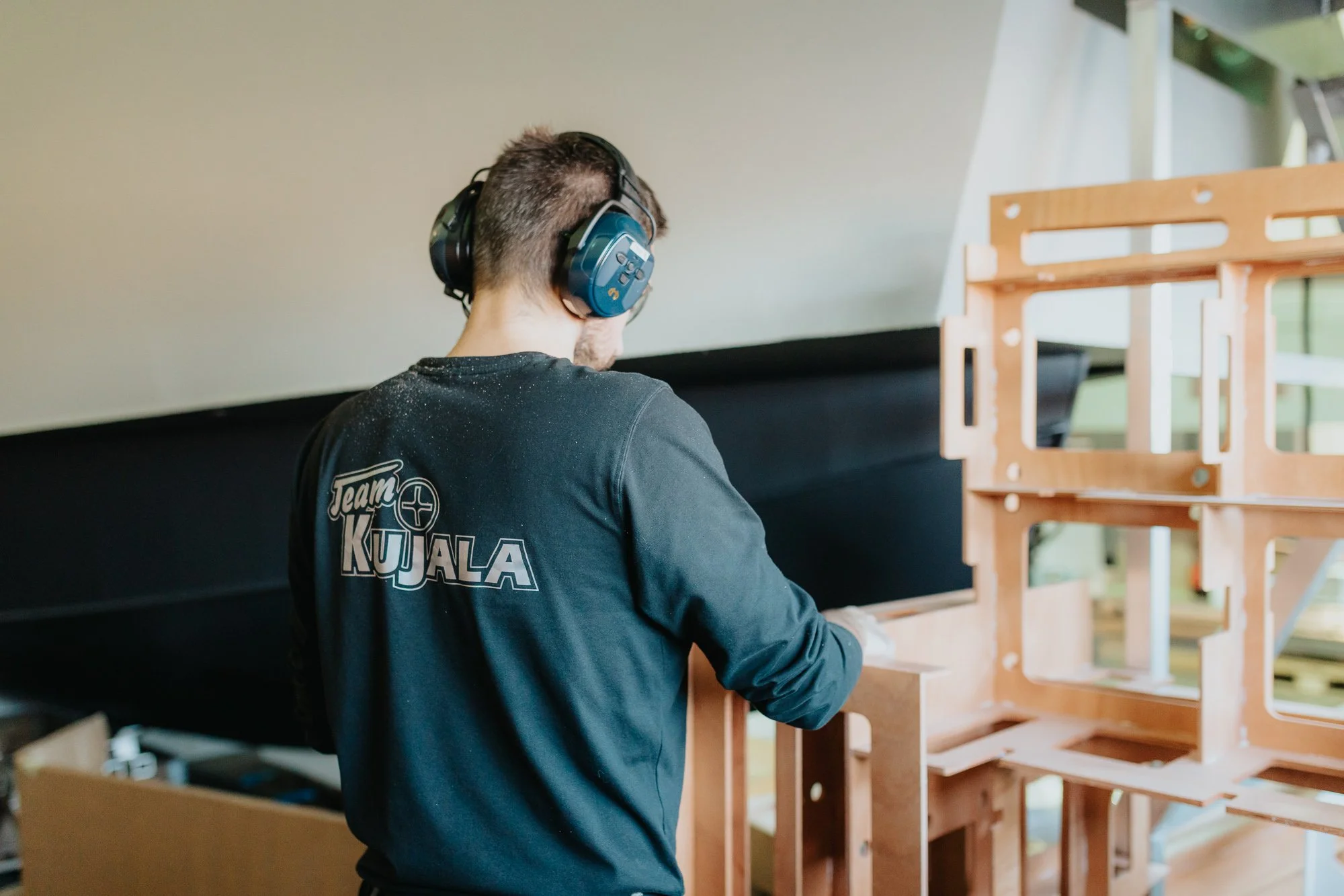 Työntekijä valmistamassa veneen puurakenteita