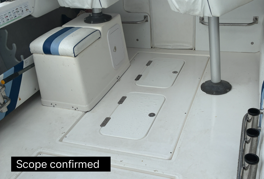 Interior of an aircraft with a white floor, hatch doors, a small cushioned seat with blue stripes, and two black circular openings on the right.