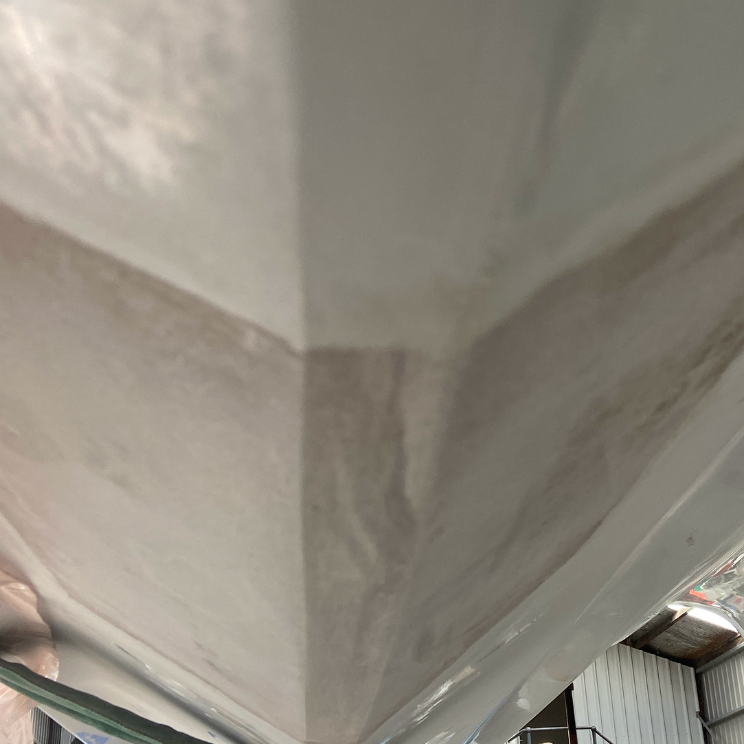 Close-up of the corner of a boat hull showing a seam and paint finish.