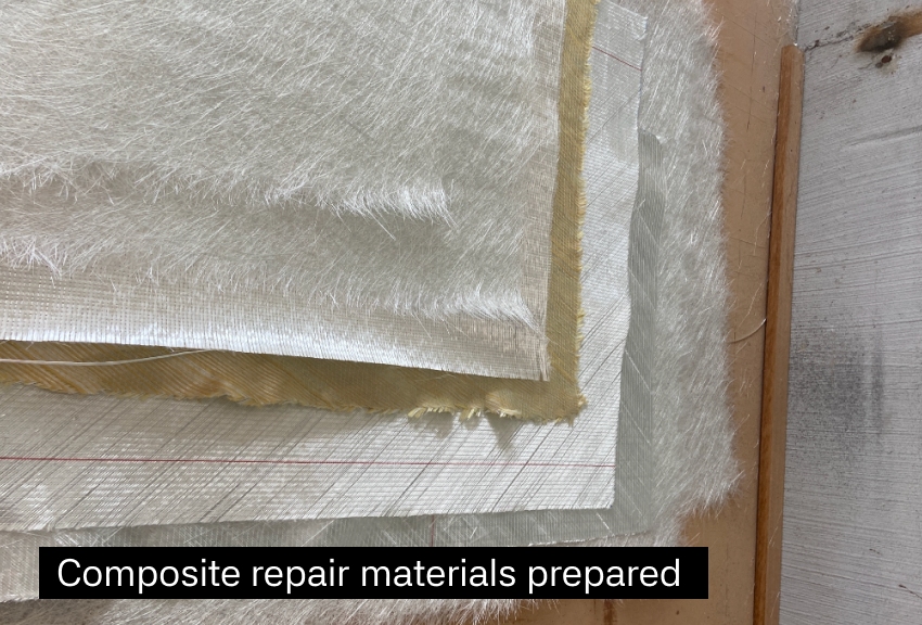A stack of composite repair materials including woven fabric, foam, and other dry prep materials on a wooden surface.