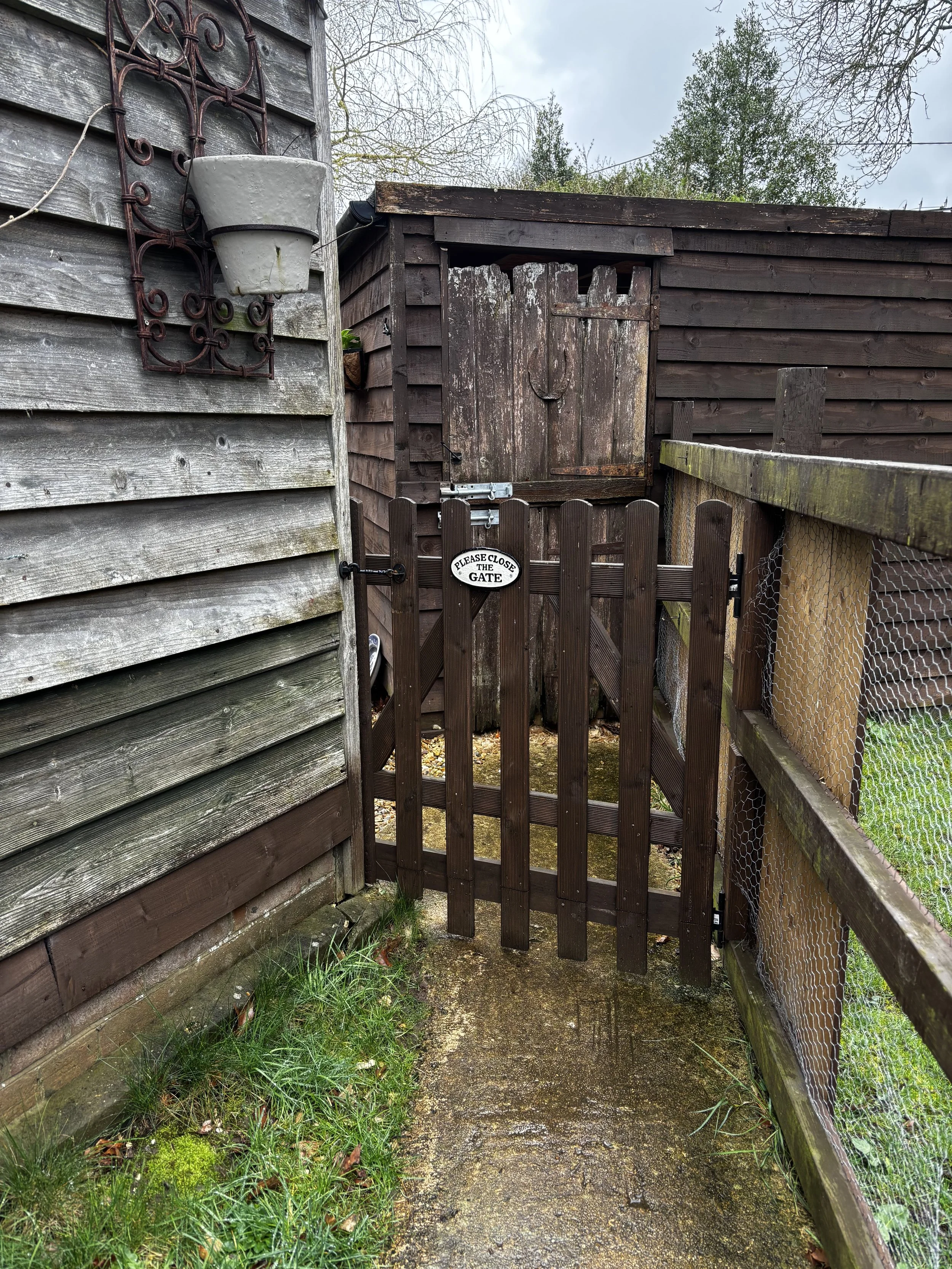 A small wooden gate with a sign that says 'Please Close the Gate' leading to the Hedgepig and Honey rural studio
