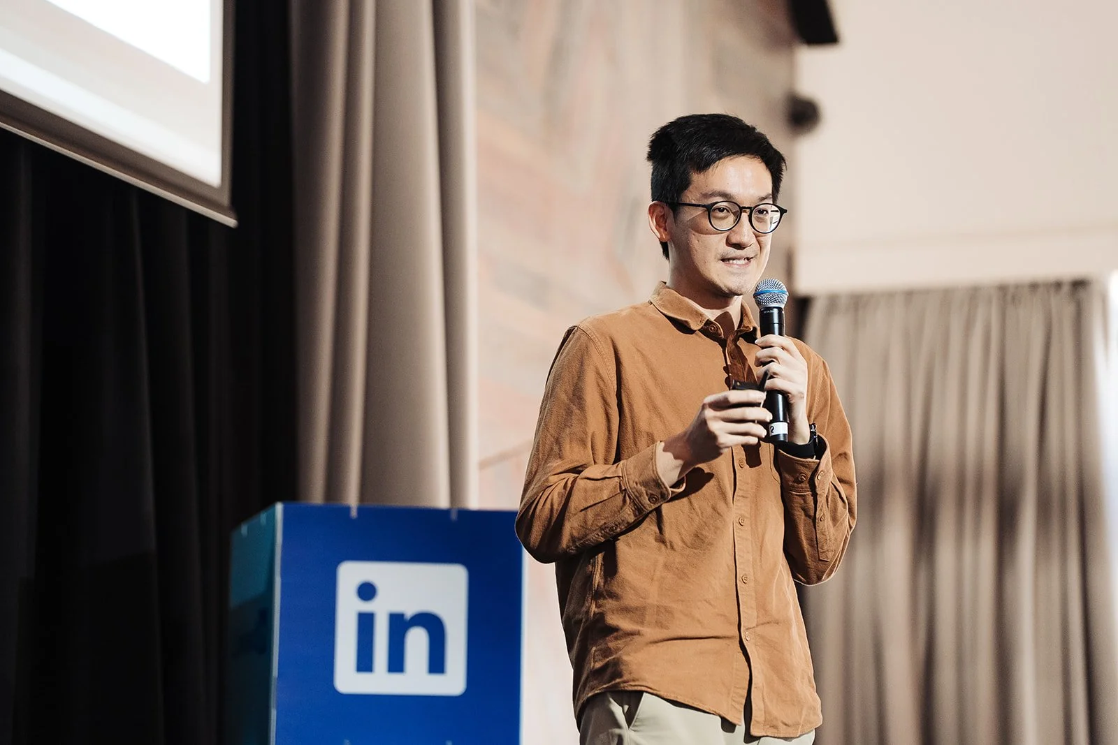 Chris Chow standing on stage for LinkedIn event.