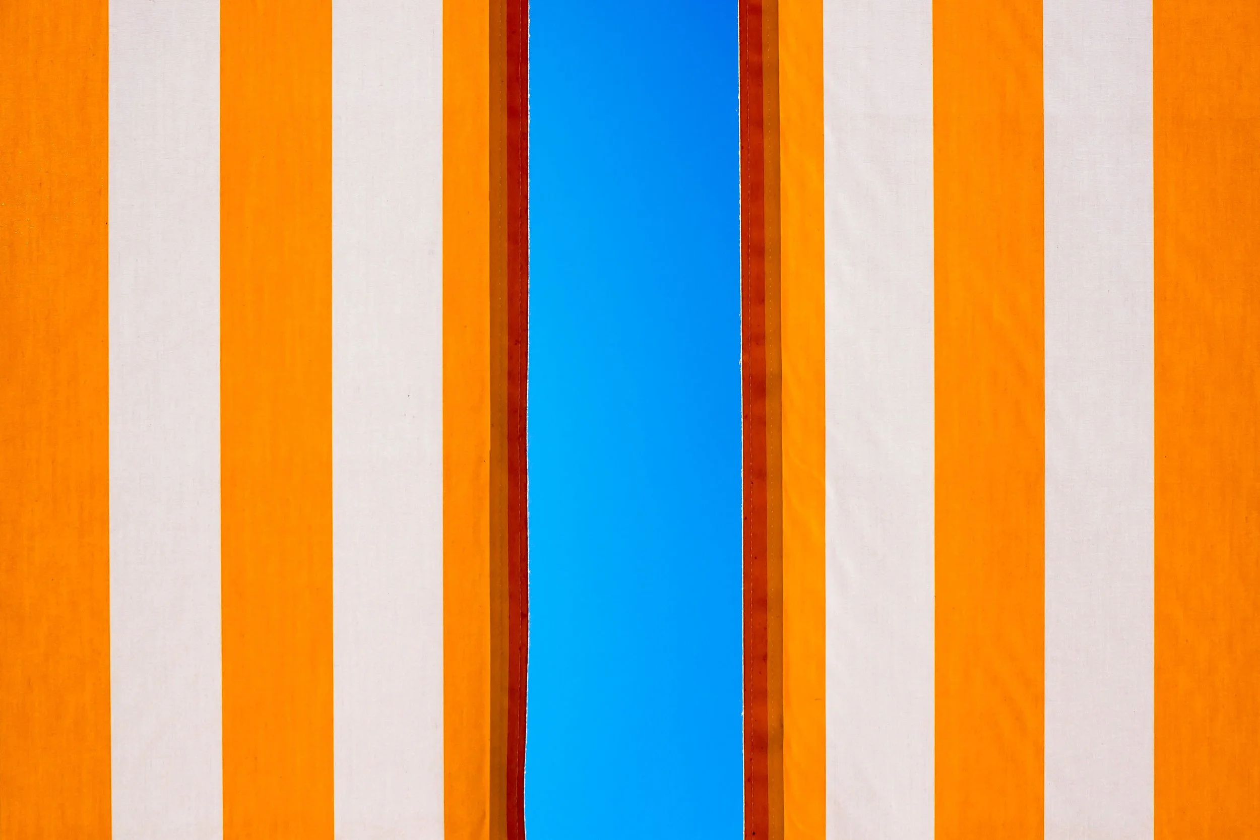 Bold vertical stripes in orange and white with blue sky — graphic abstract color-field photography by Kimberly Poppe, represented by ZOZI Gallery
