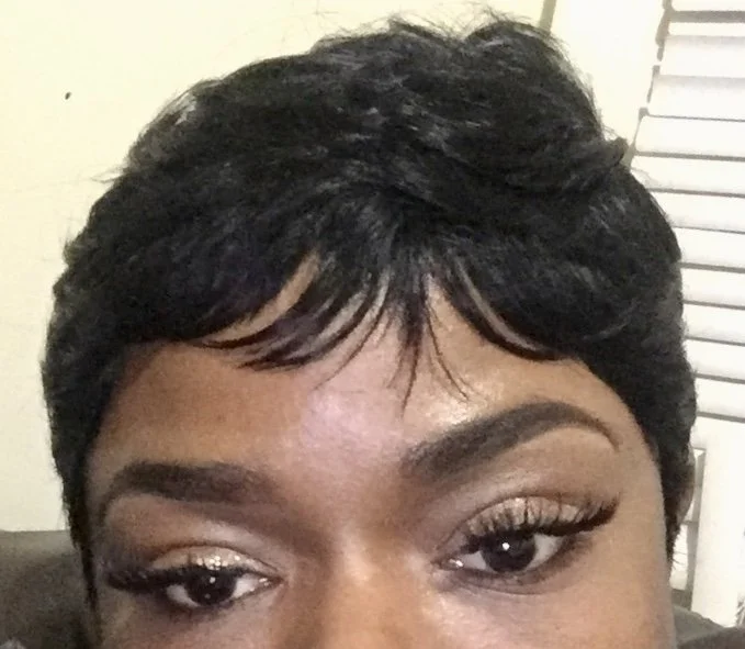 Close-up of a woman's face showing her eyes and short black hairstyle.