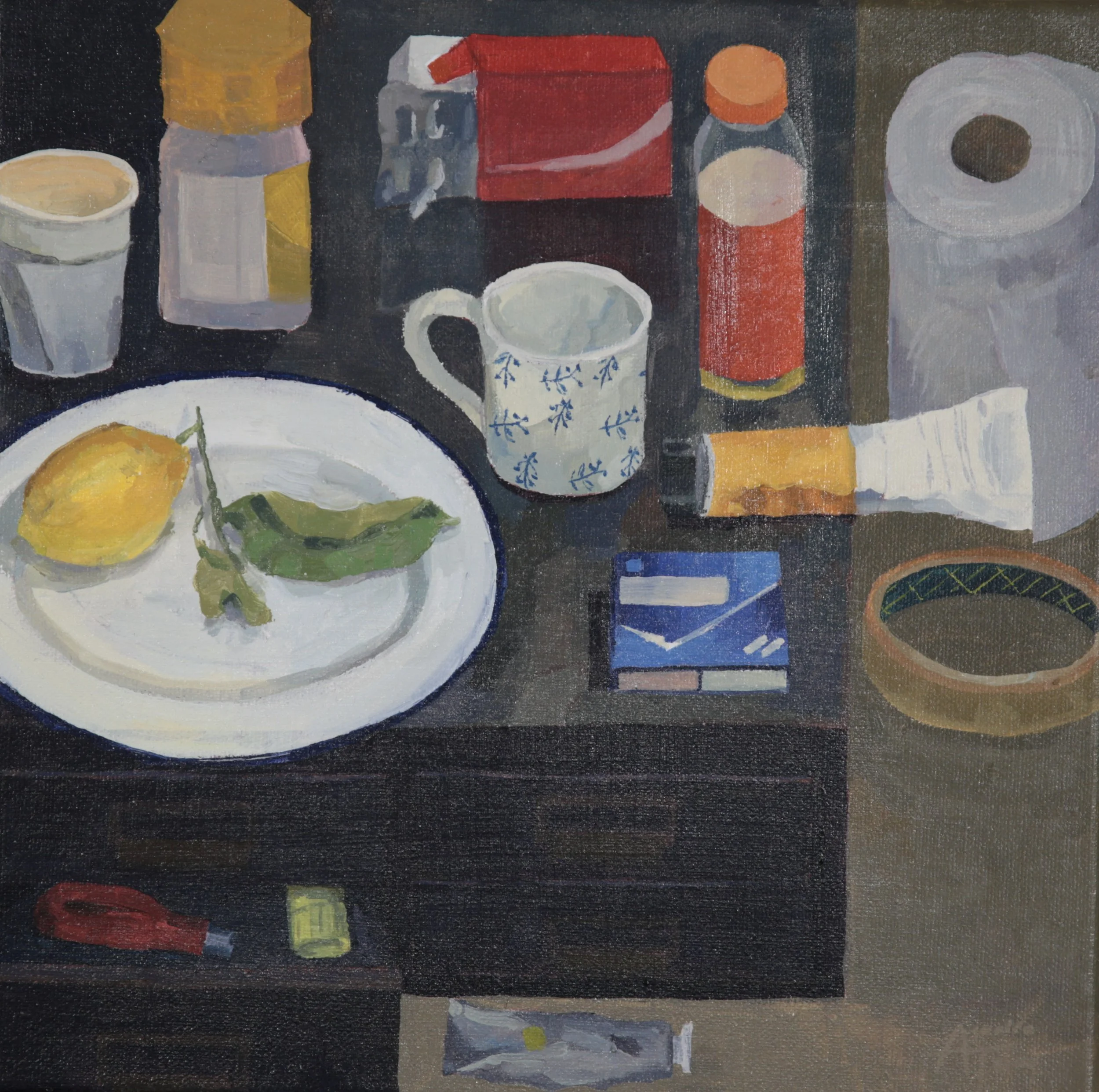 A still life painting featuring a white bowl with a lemon, a cup with a blue floral pattern, and detritus such as pain killer packets, and  including bottles and tubes of paint on a dark table.