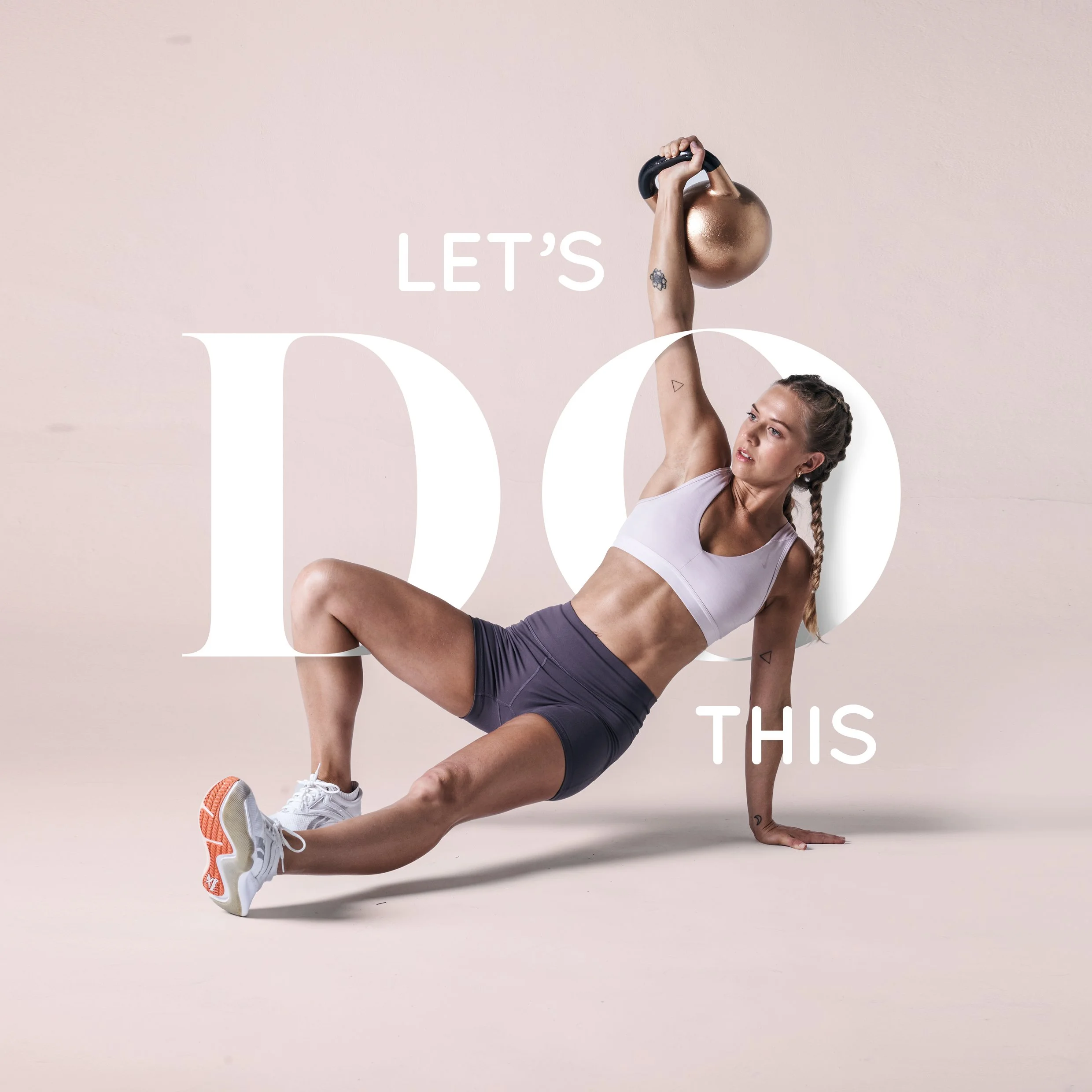 A woman performing a one-arm side plank with her right arm holding a kettlebell, looking focused, wearing a white tank top and purple shorts, against a plain beige background.