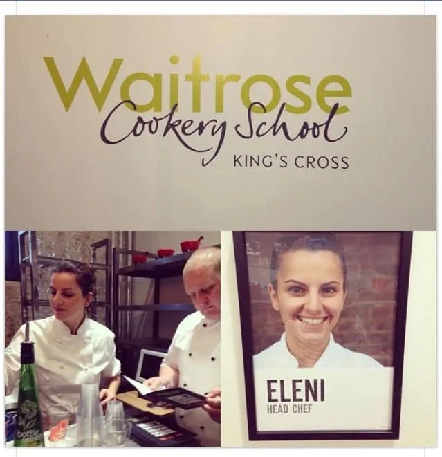 Sign for Waitrose Cookery School at King's Cross with a photo of head chef Eleni and two chefs preparing food.
