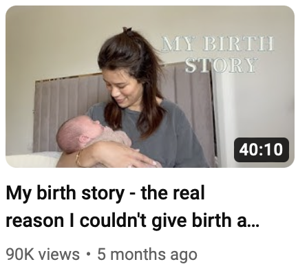 A woman holding a newborn baby in a hospital room, with a sign reading 'MY BIRTH STORY' on the wall.
