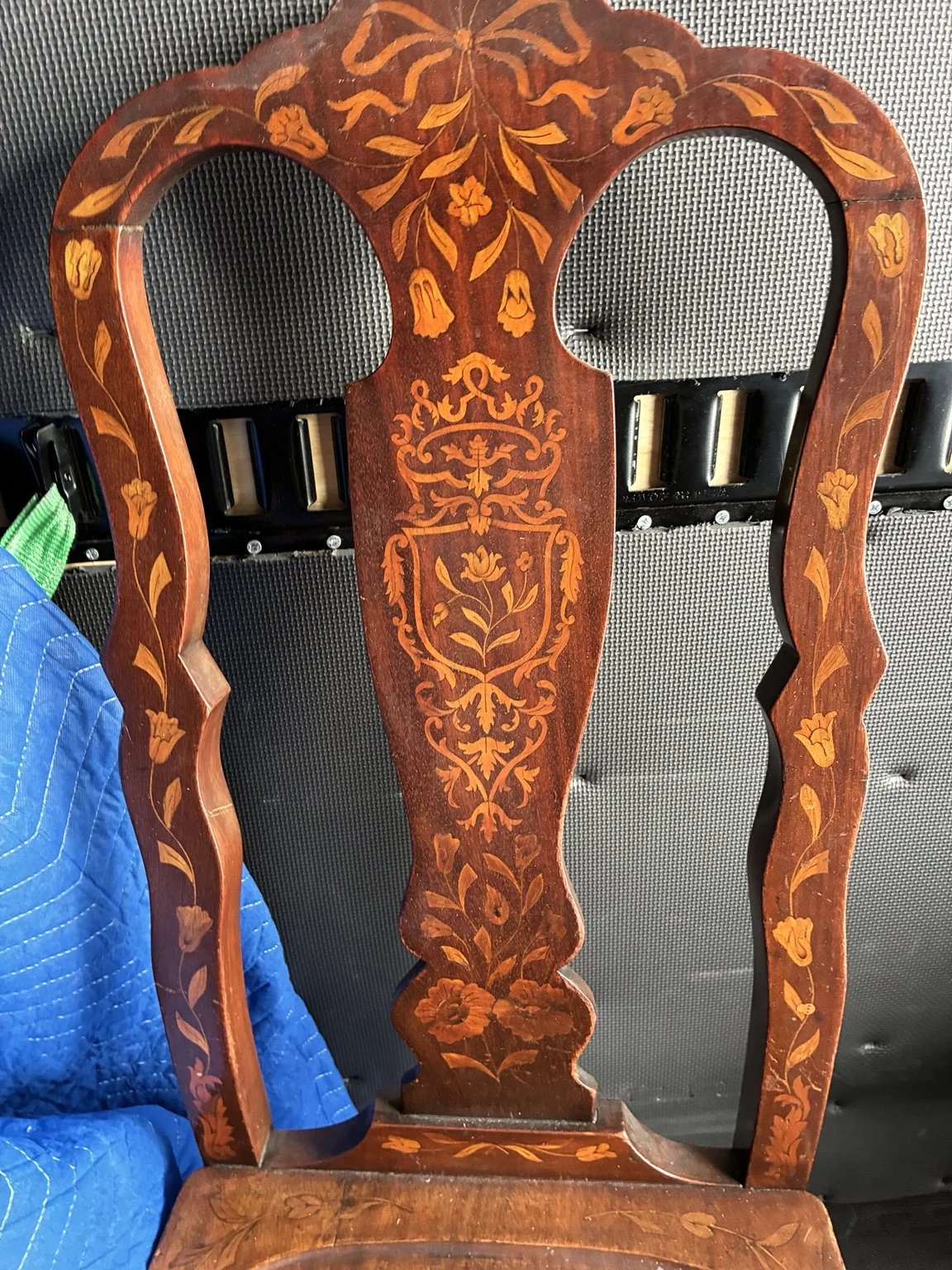 Decorative inlaid wooden chair with intricate marquetry.
