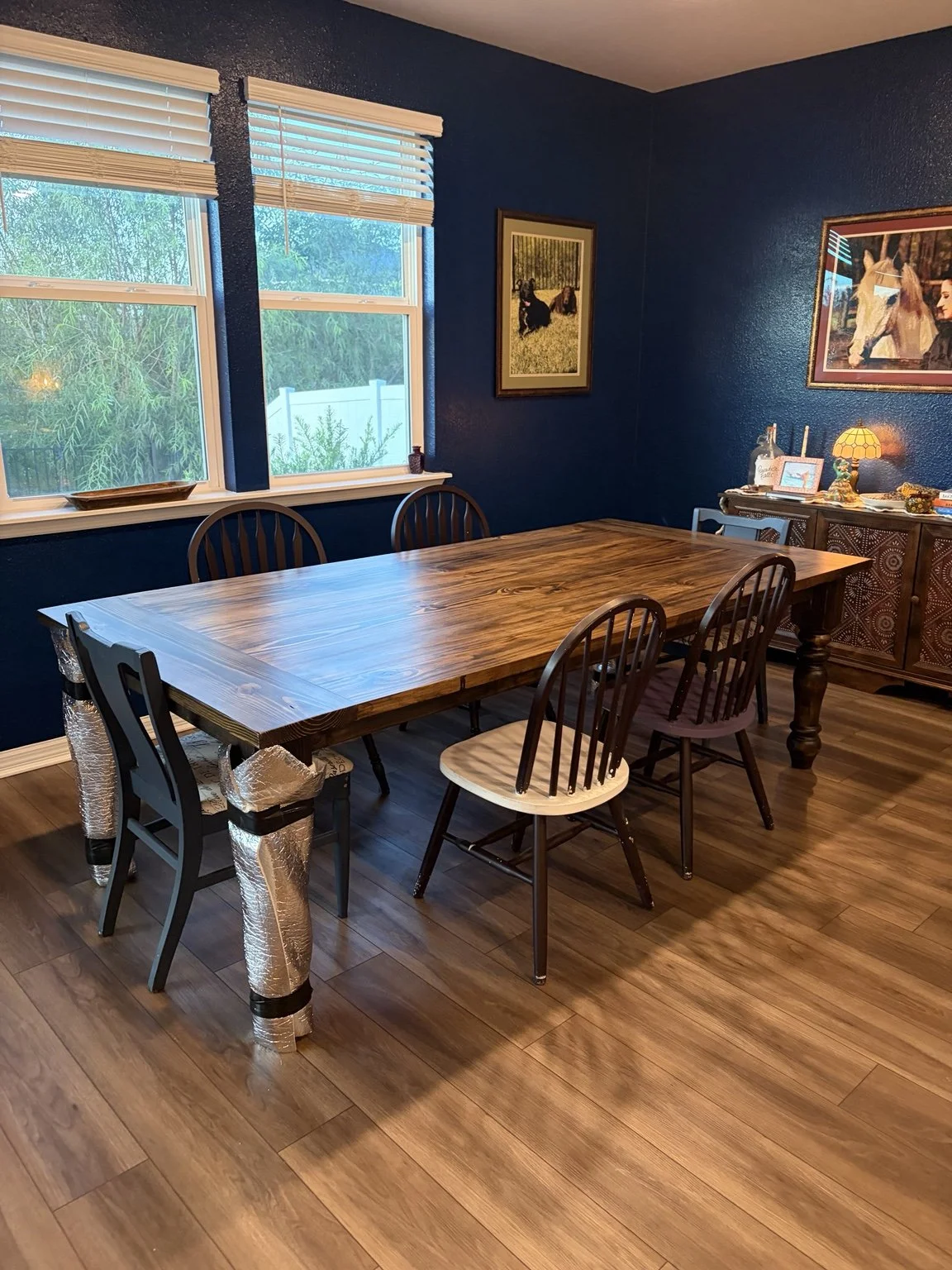 Handmade 8-foot farmhouse table with hand-turned, one-piece legs in its dining room after delivery by Slohaven Transfer.