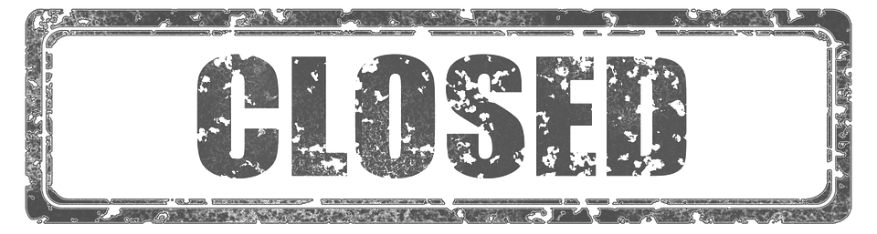 A rectangular, distressed black and white sign with the word "CLOSED" in large capital letters.