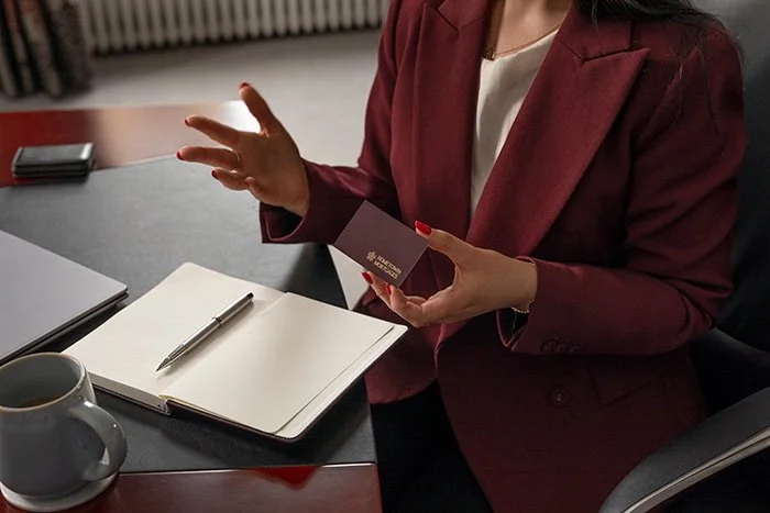aisling holding hometown mortgages business card at desk with open notebook