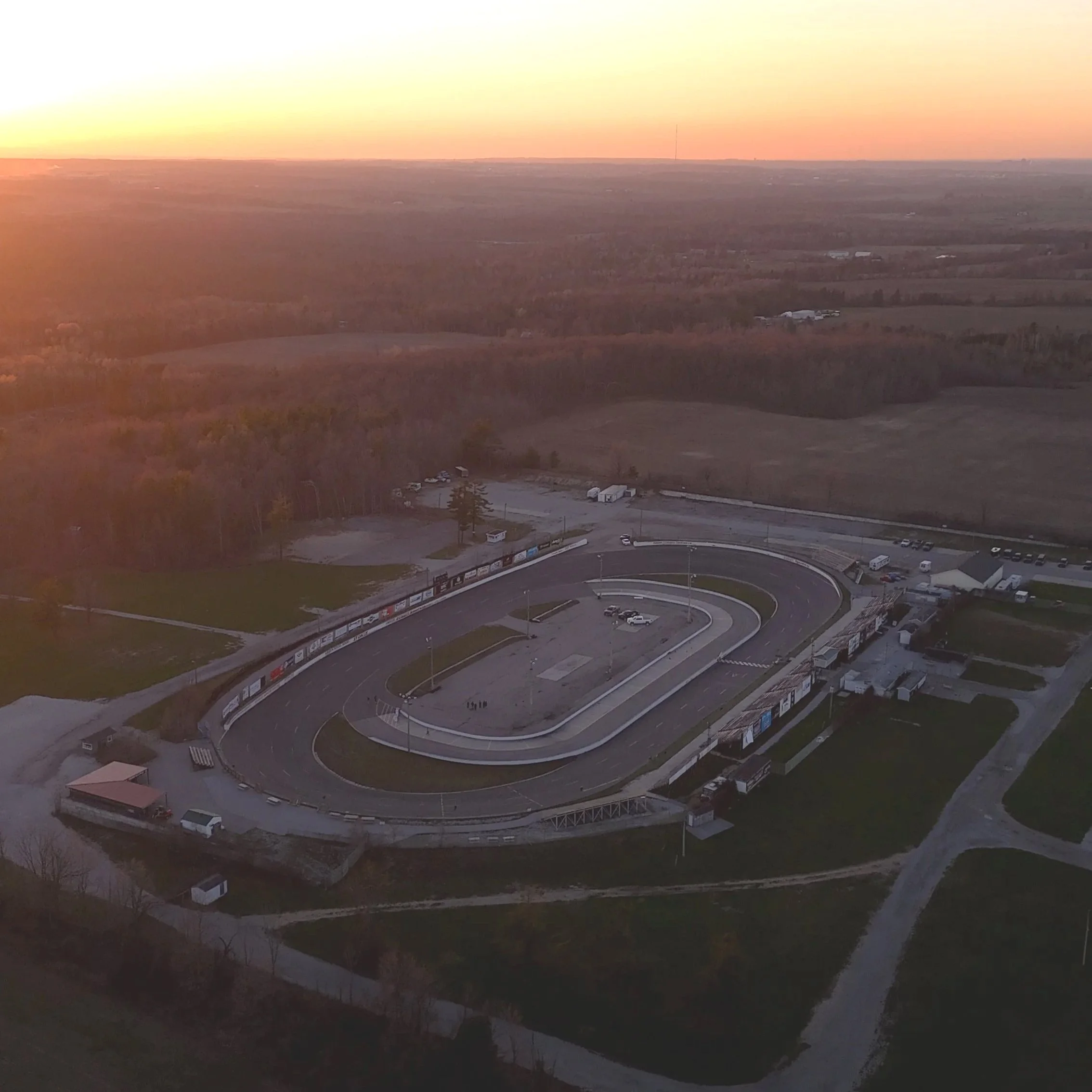 A wide panoramic view of a rural landscape at sunset of Sunset Speedway