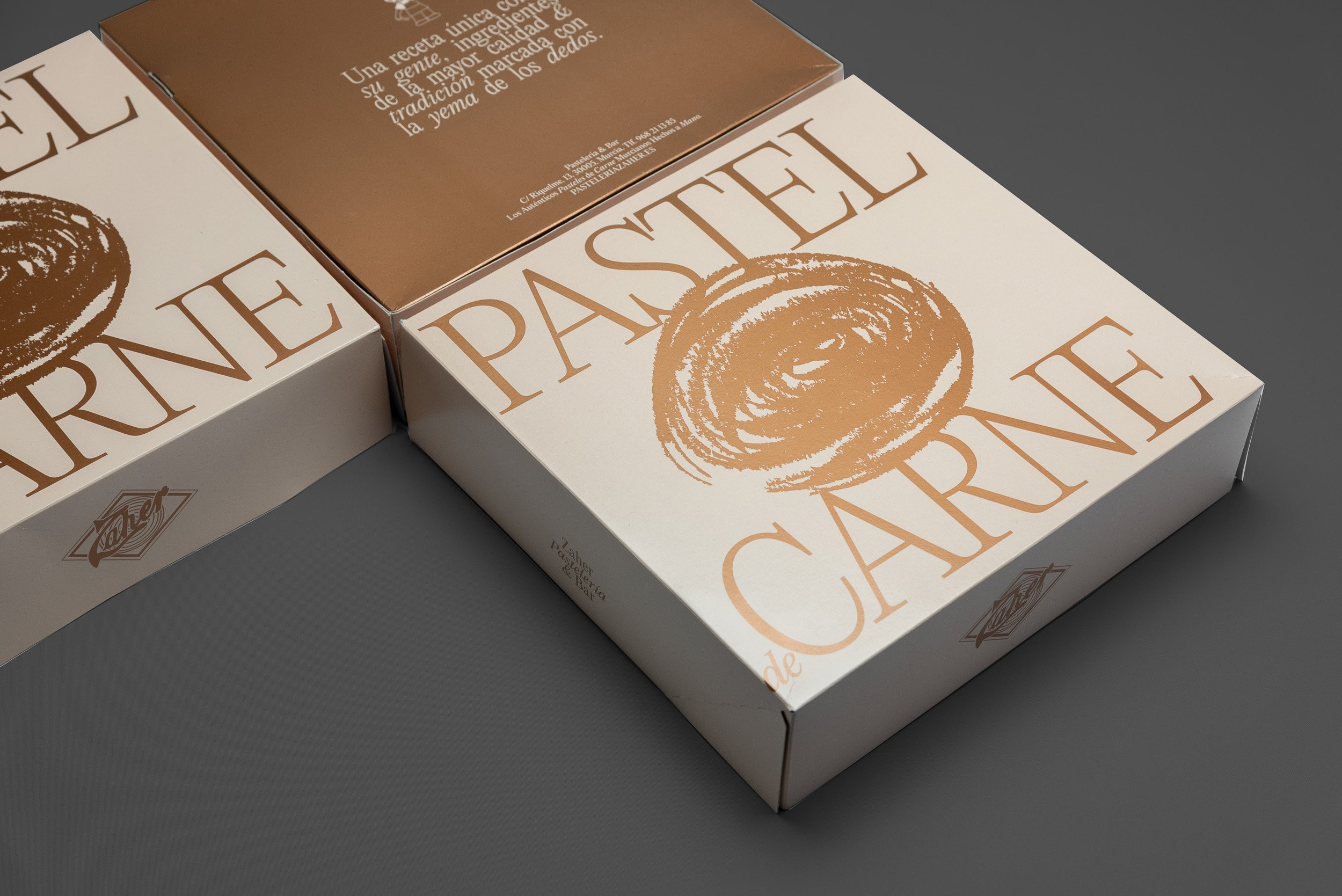 Fotografía de cajas para pasteles de carne con iluminación de estudio sobre fondo gris.