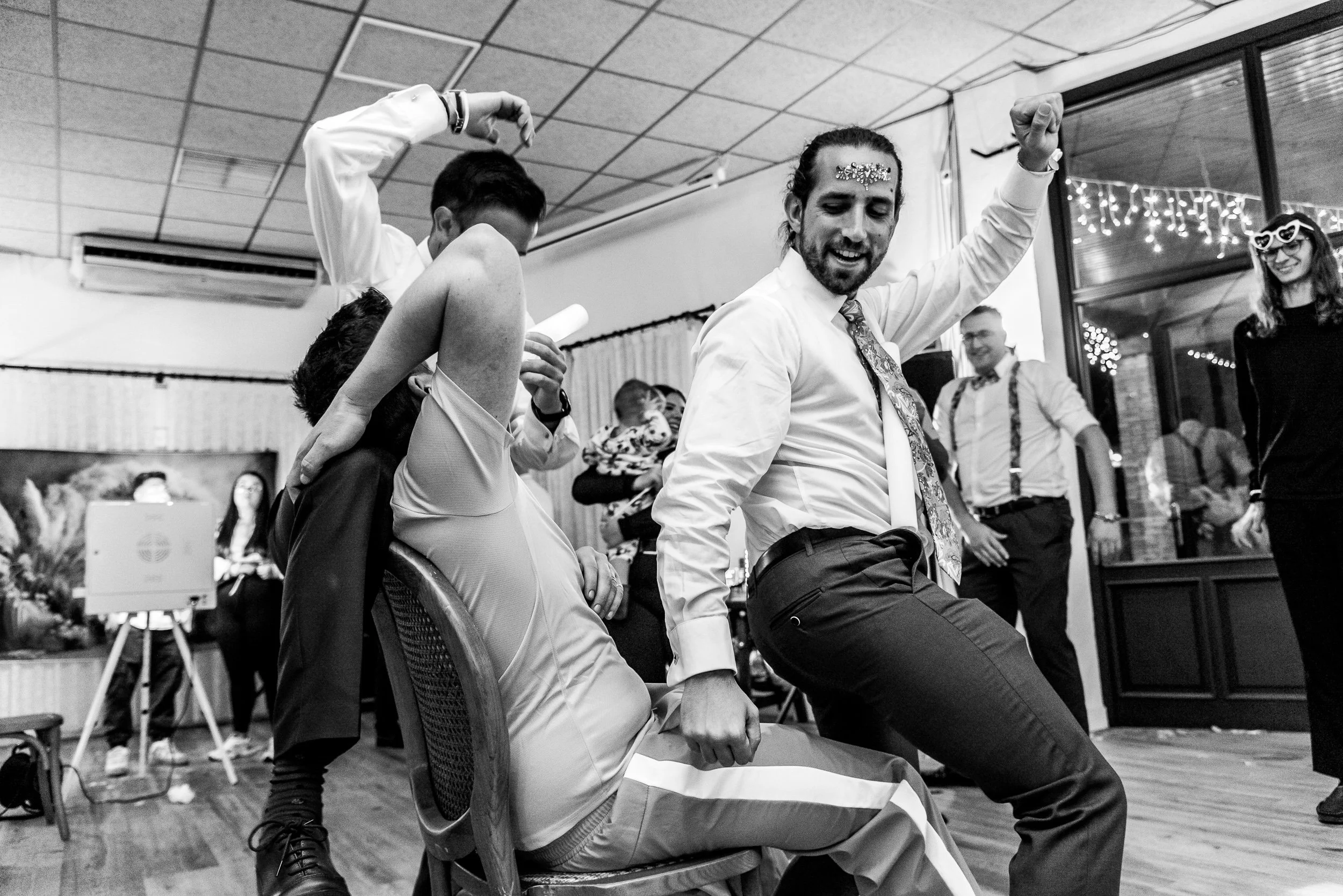 Personas bailando en una fiesta con decoración de luces y amigos sonriendo.