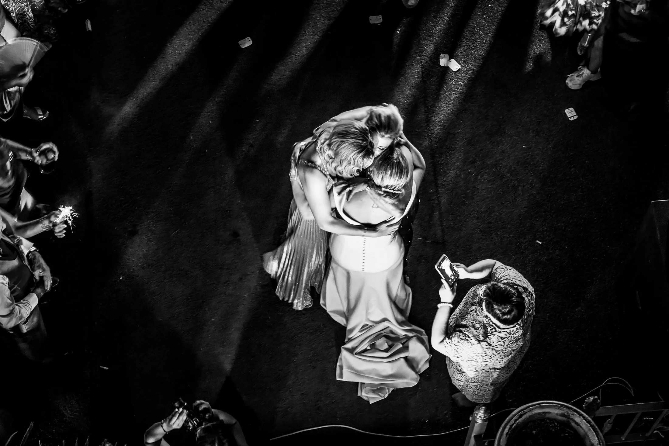 Personas bailando abrazadas juntas en una boda en vista aérea en blanco y negro.