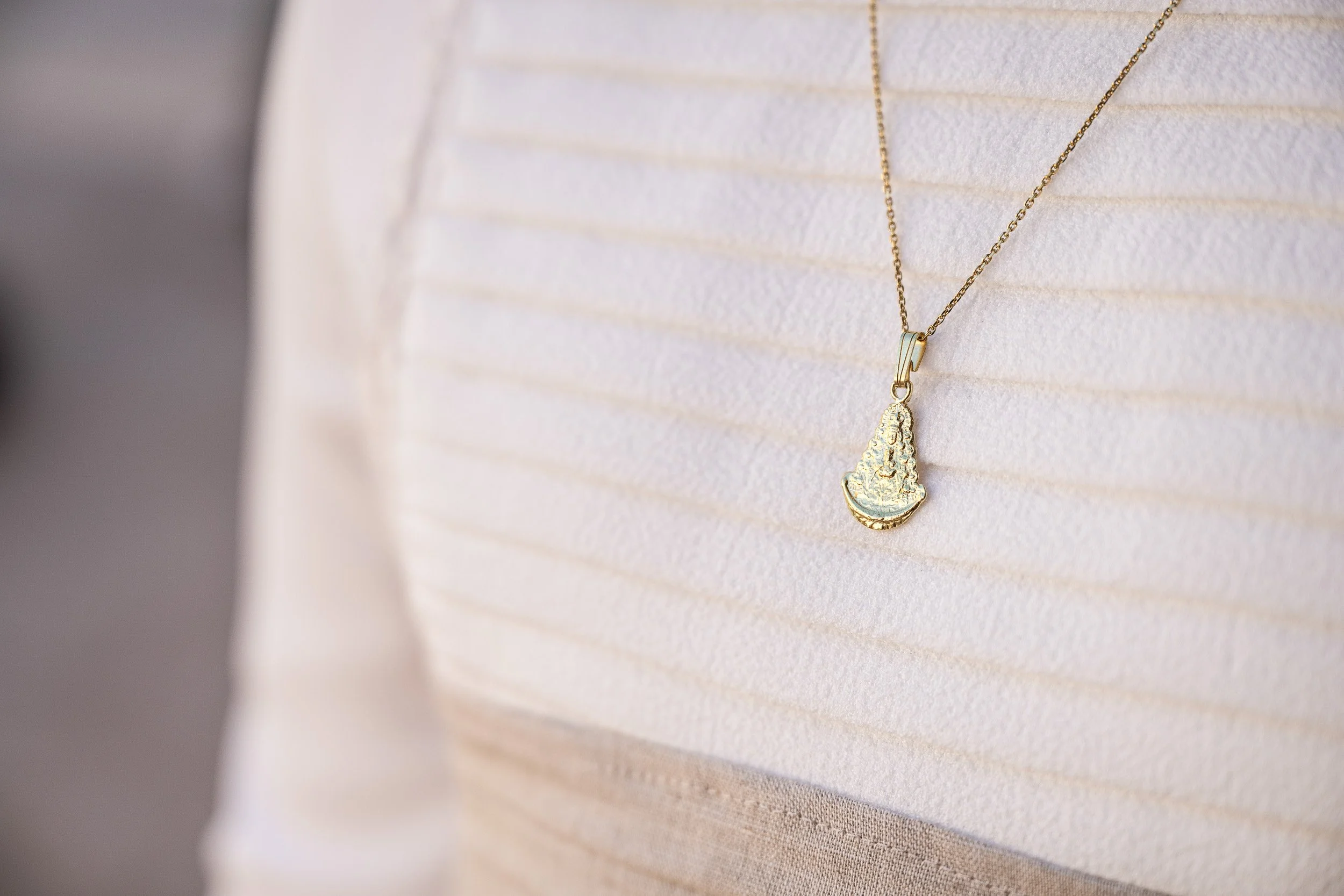 Cadena con colgante dorado en forma de figura.