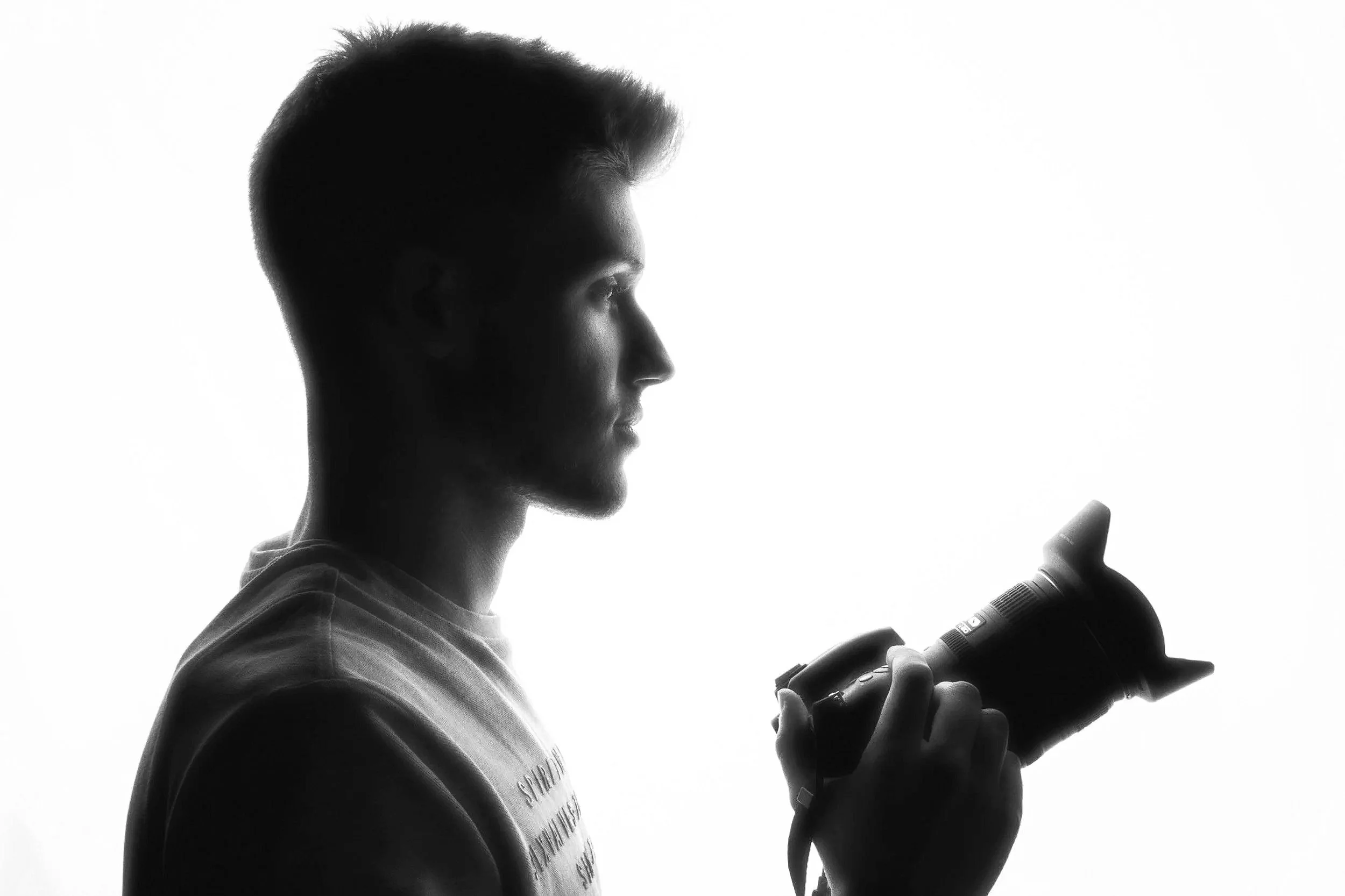 Cristian Pérez, fotógrafo en Murcia, sosteniendo su cámara en un retrato en blanco y negro.