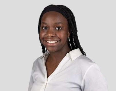 Portrait of a woman with braided hair wearing a white collared shirt and smiling.