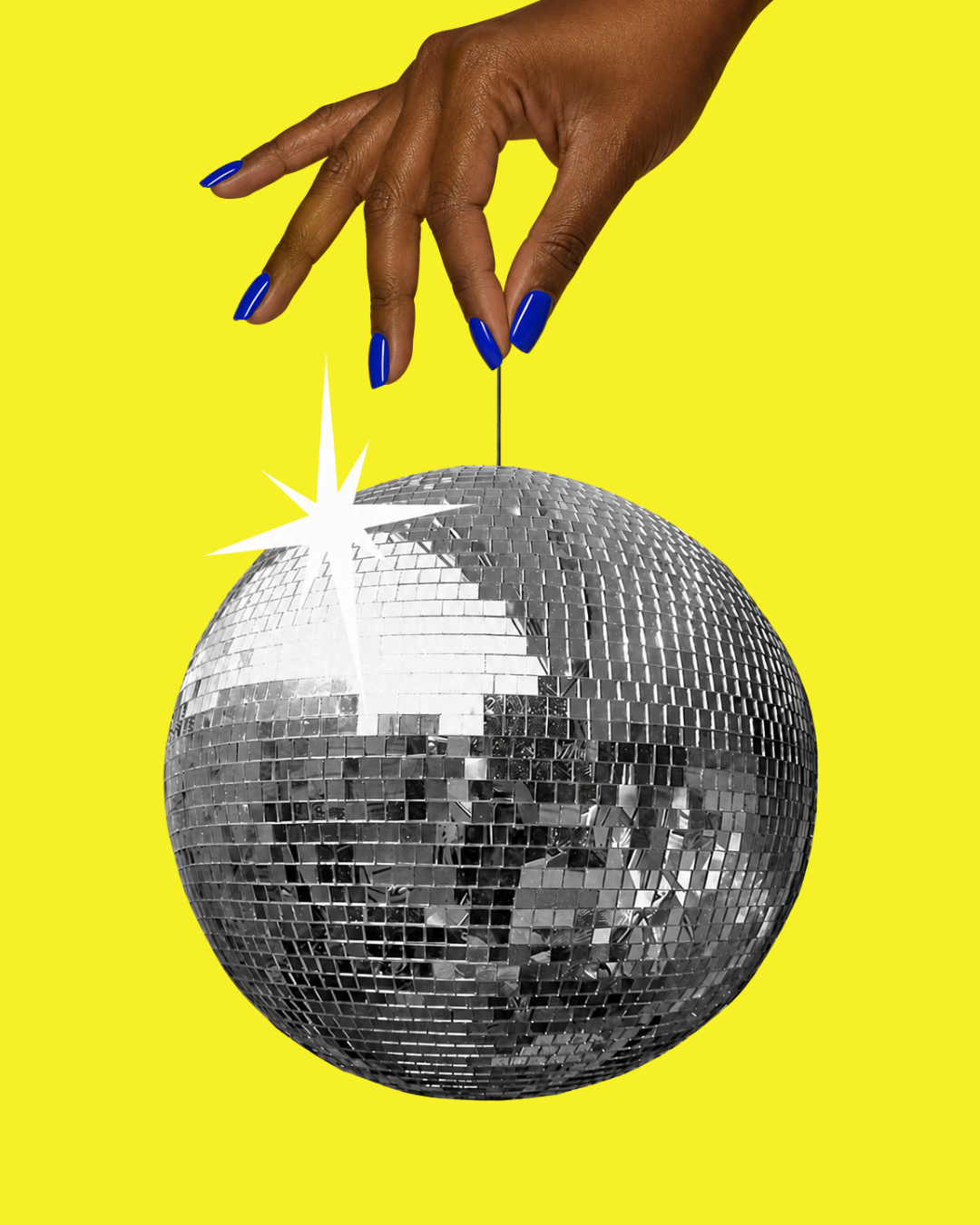 A hand with blue nails holding a string attached to a disco ball against a bright yellow background.