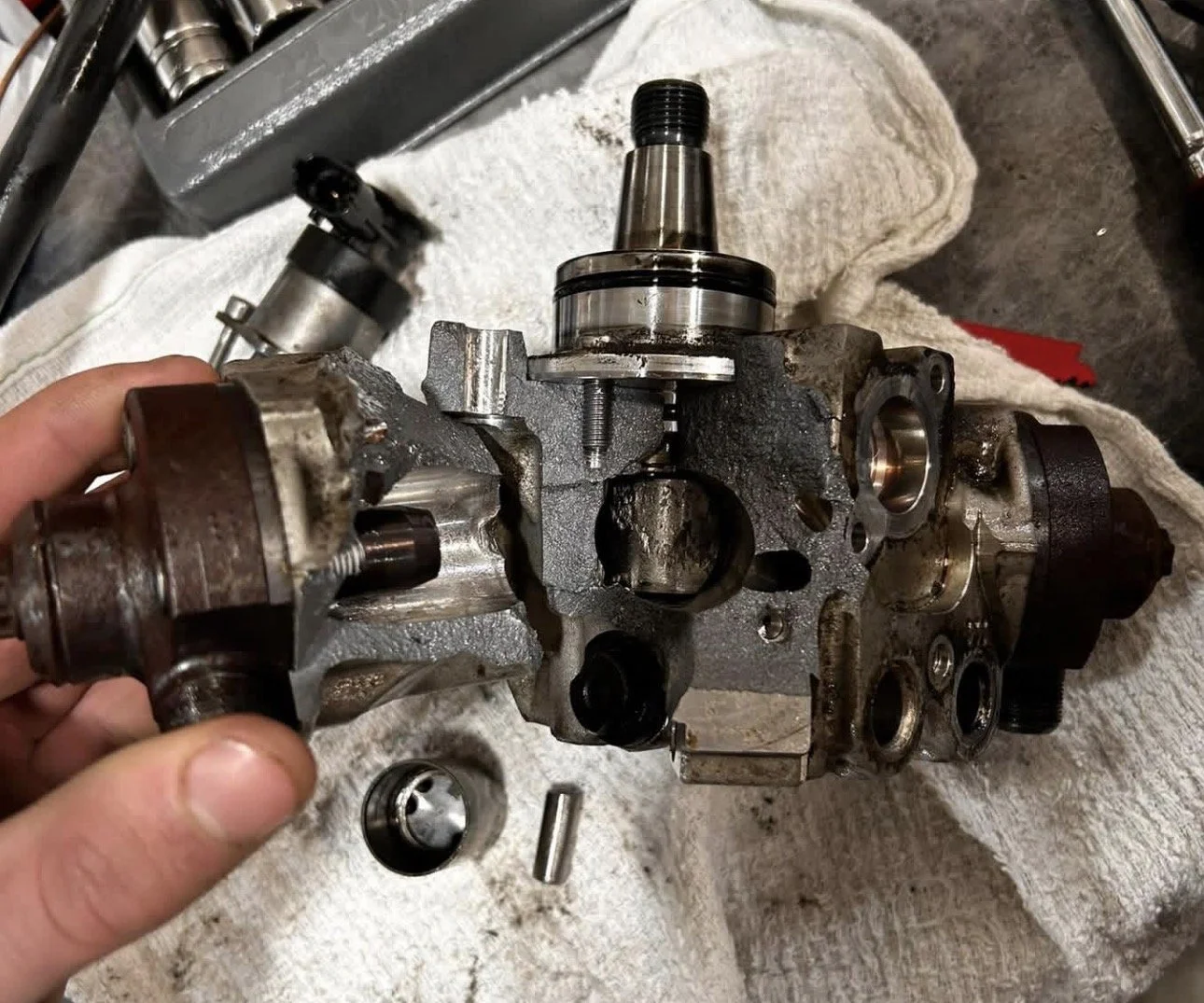 Internal damage of a Bosch CP4 high-pressure fuel pump caused by contaminated fuel and poor fuel filter maintenance on a diesel engine.