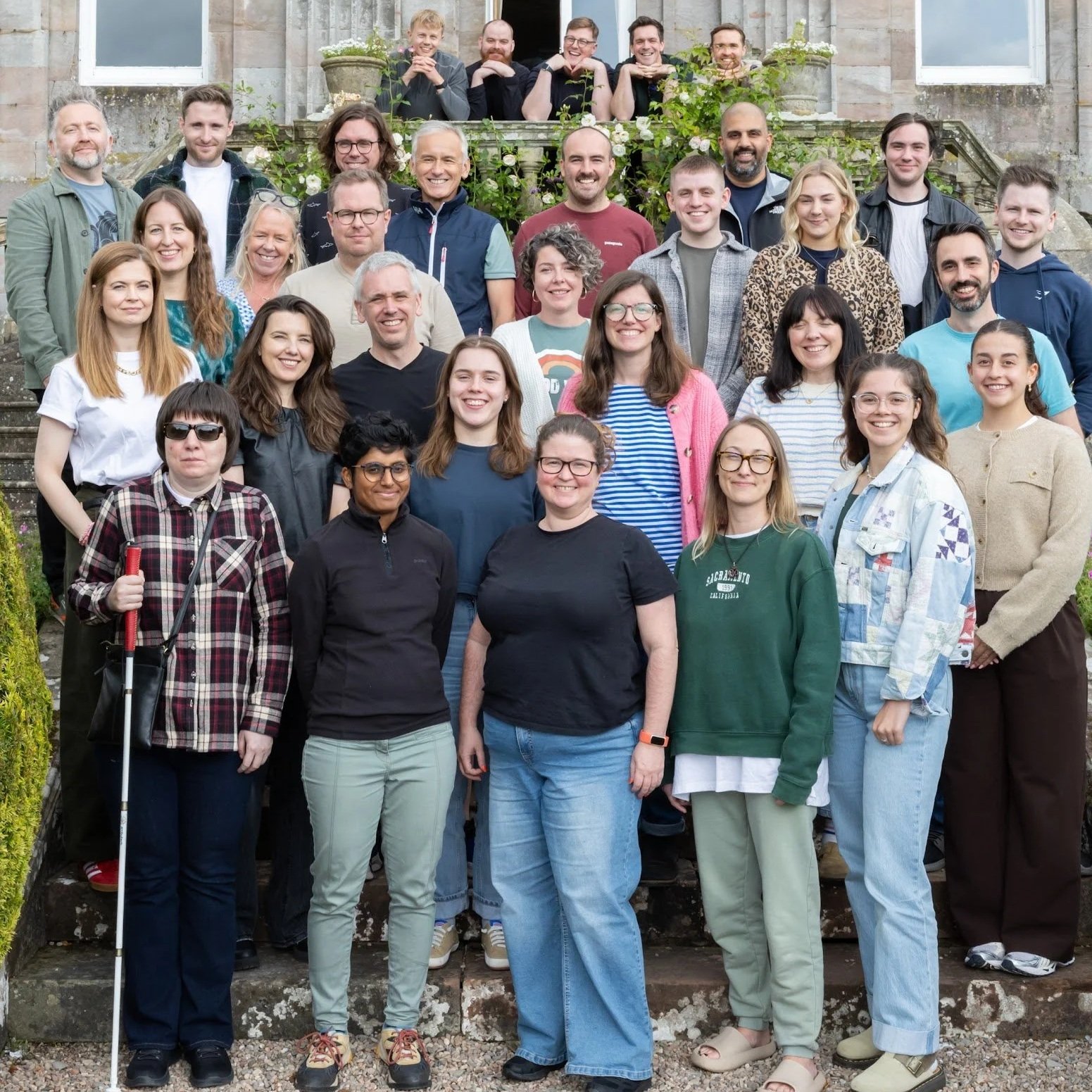 The Nile team standing on stairs outside at Springkell house