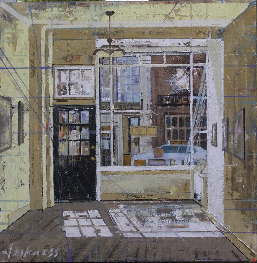 An interior view of a small room with a large window and glass door leading outside or to another room, with sunlight casting shadows on the wooden floor. The room has yellow walls, a ceiling fan with lights, and several framed pictures on the walls.