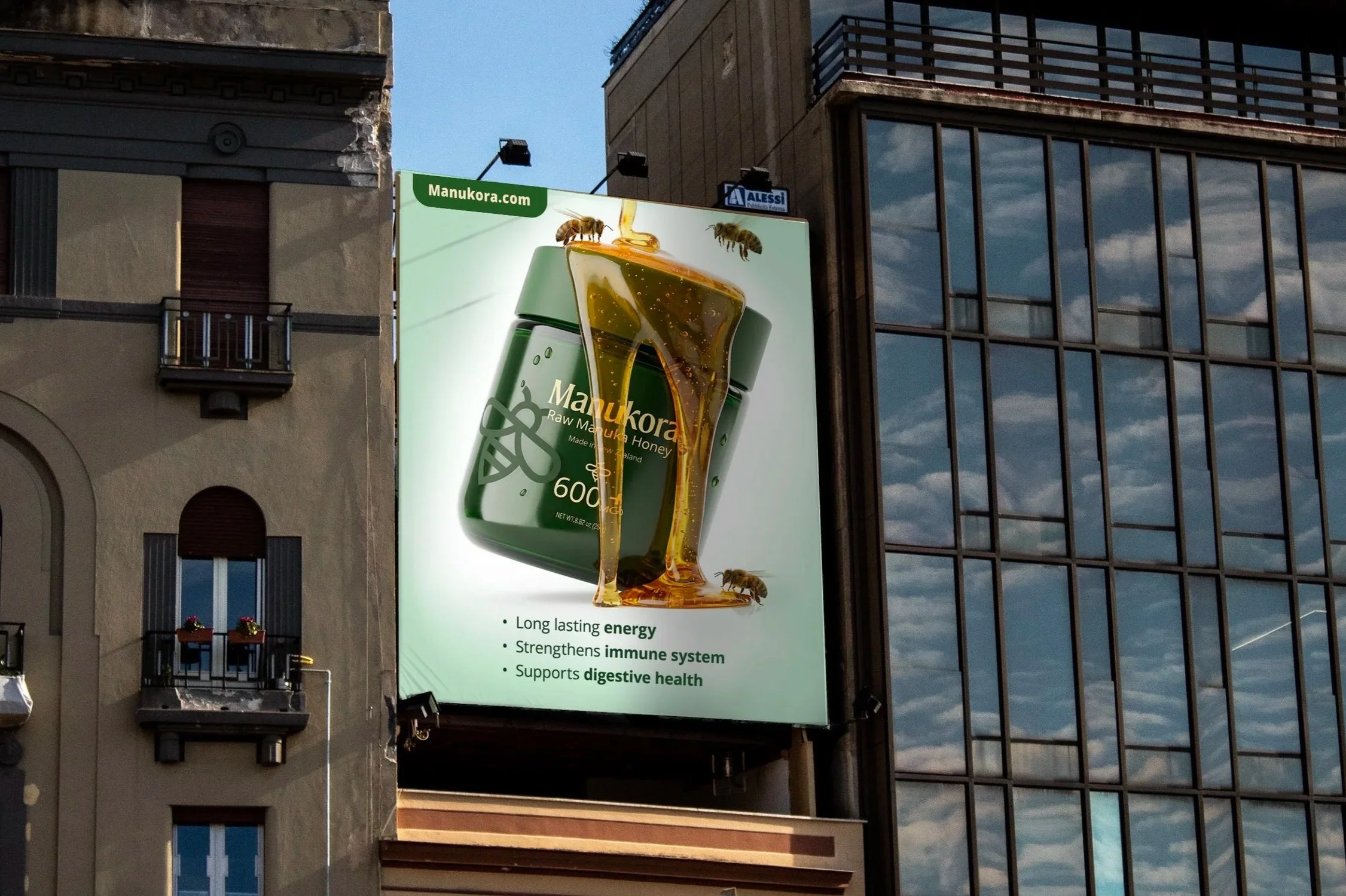 A large billboard advertising Manukora raw honey, showing a jar of honey with bees around it, and text highlighting the benefits of honey such as providing energy, strengthening the immune system, and supporting digestive health.