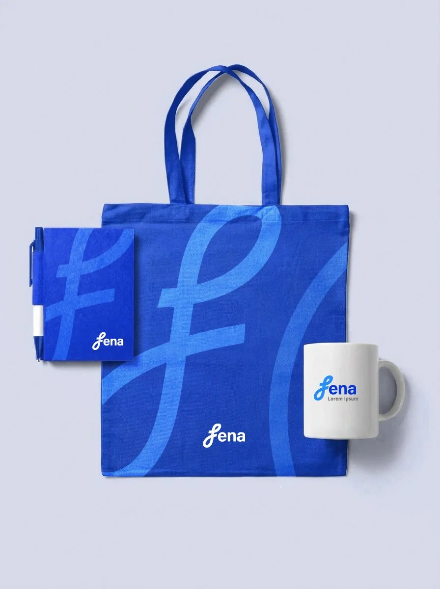 Blue tote bag, notebook, ceramic mug, and pen with the 'fena' logo and branding.