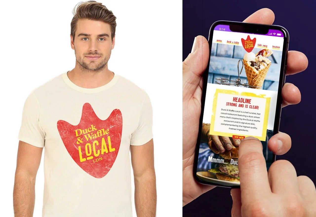 A man is wearing a white T-shirt with a red heart-shaped logo that says "Duck & Waffle Local" in yellow text. Someone is holding a smartphone displaying a website for Duck & Waffle Local, showing an ice cream cone and menu options.