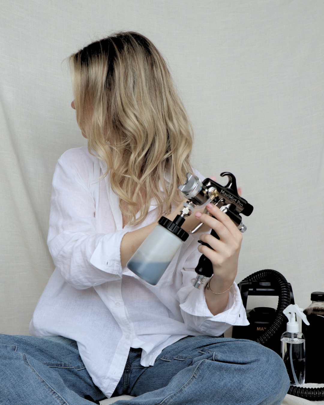 Woman with mobile spray tanning equipment.