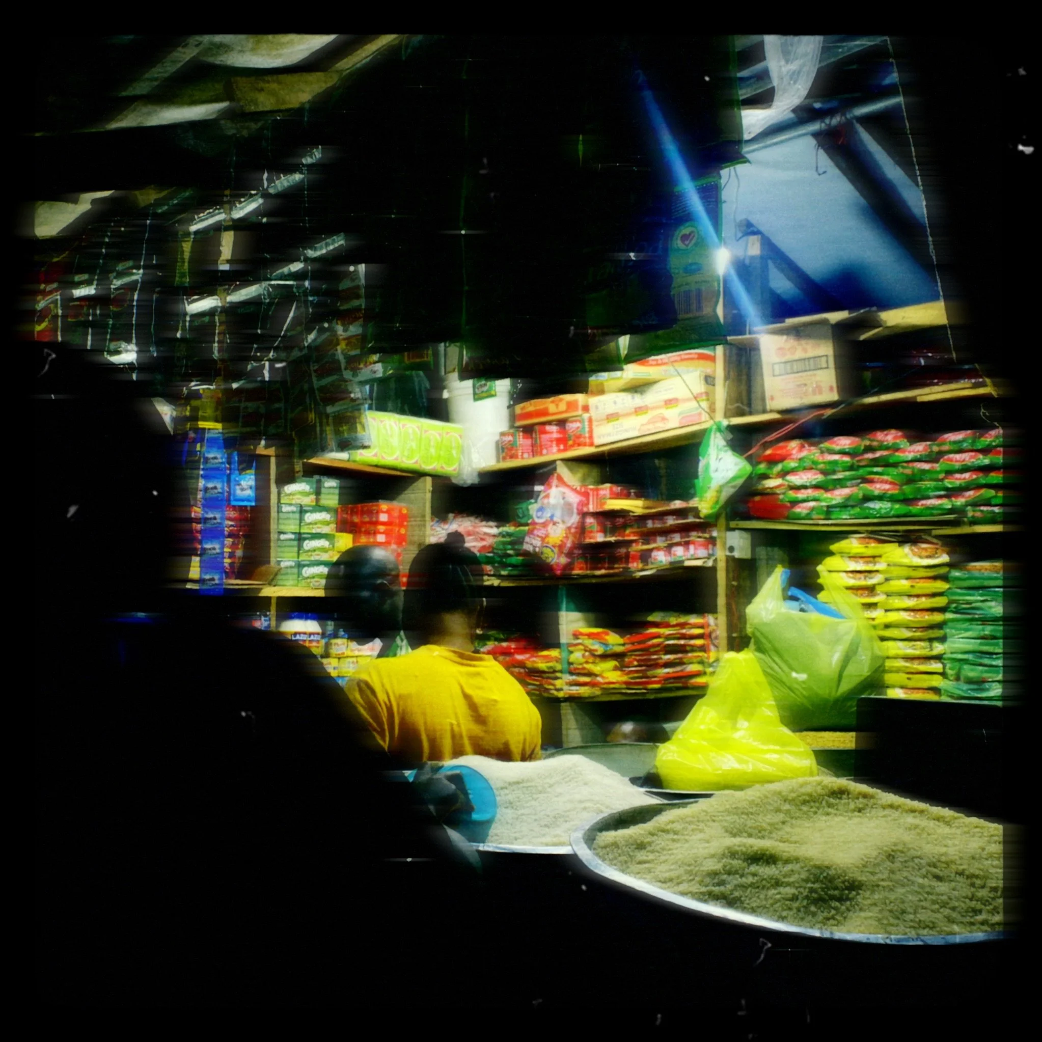Image of a grocery store aisle with shelves stocked with various food products, taken through a distorted or unclear lens.