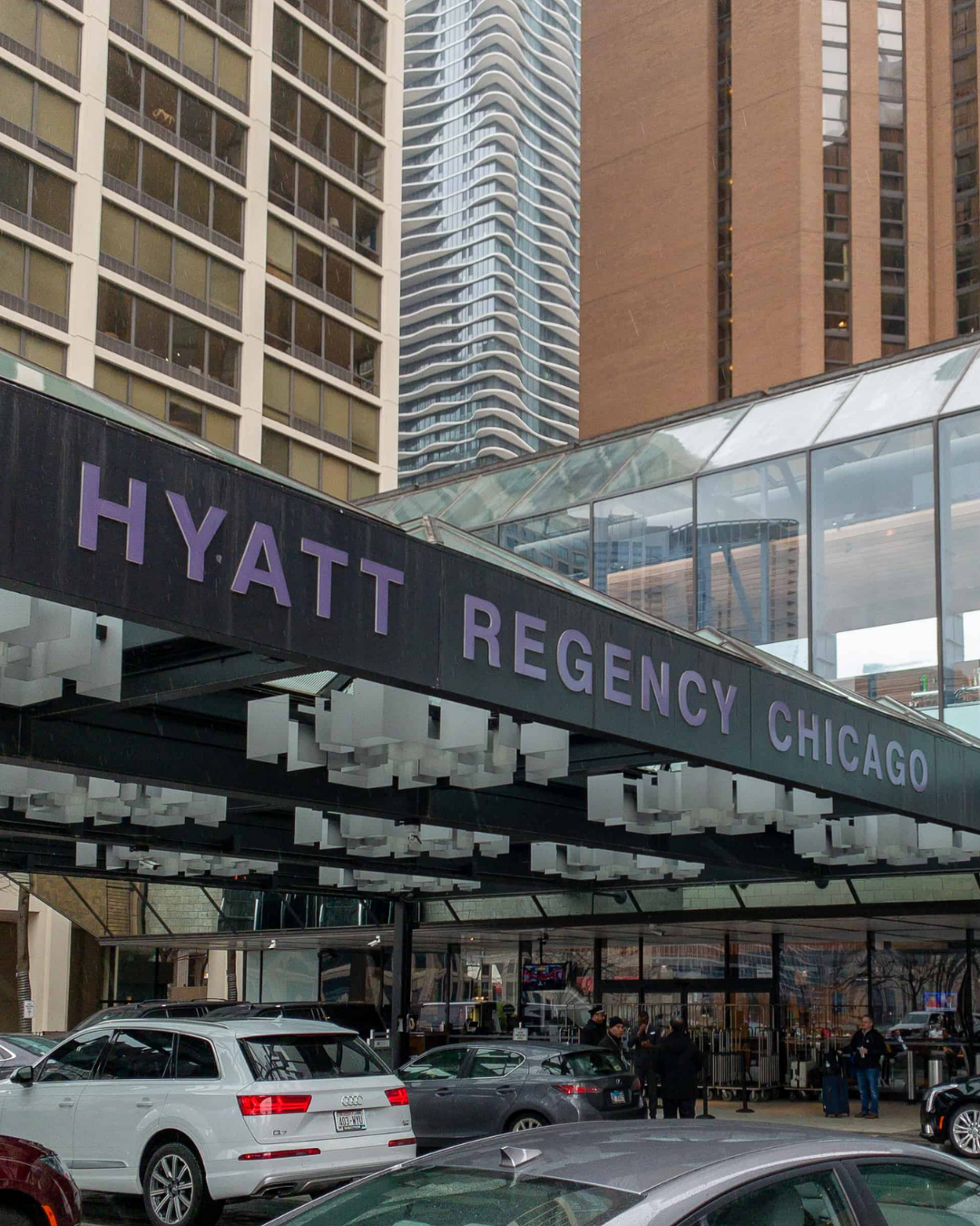 Family support services showing entrance of Hyatt Regency Chicago with cars parked in front and tall buildings in the background.