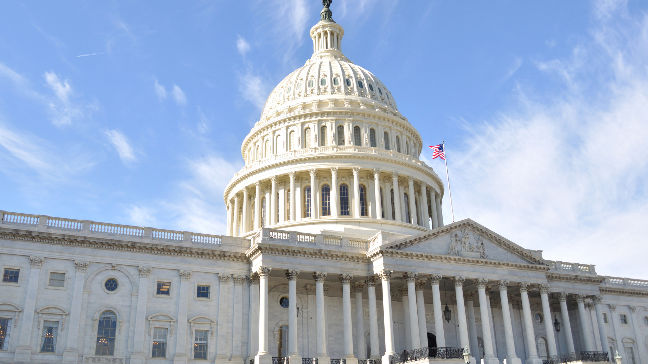 The United States Capitol building with an American flag flying, seen under a clear blue sky representing FFTA annual public policy institute.