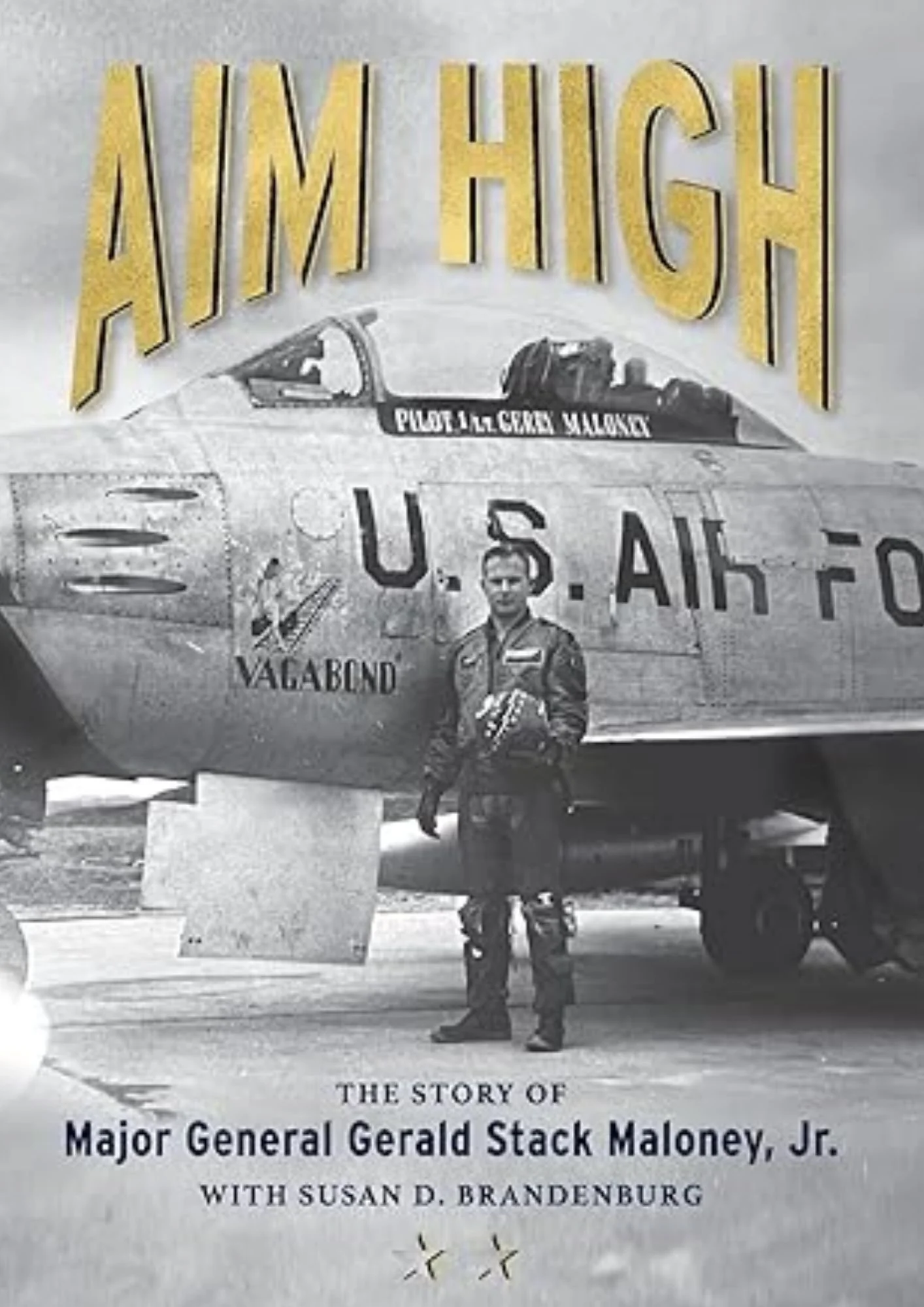 Book cover titled 'AMERICAN HIGH' with a photo of a pilot in uniform standing in front of a military airplane that has writing 'PILOT & CREW MALONEY' on the side. The cover also states 'THE STORY OF Major General Gerald Stack Maloney, Jr.' with authors Susan D. Brandenburg and another author.