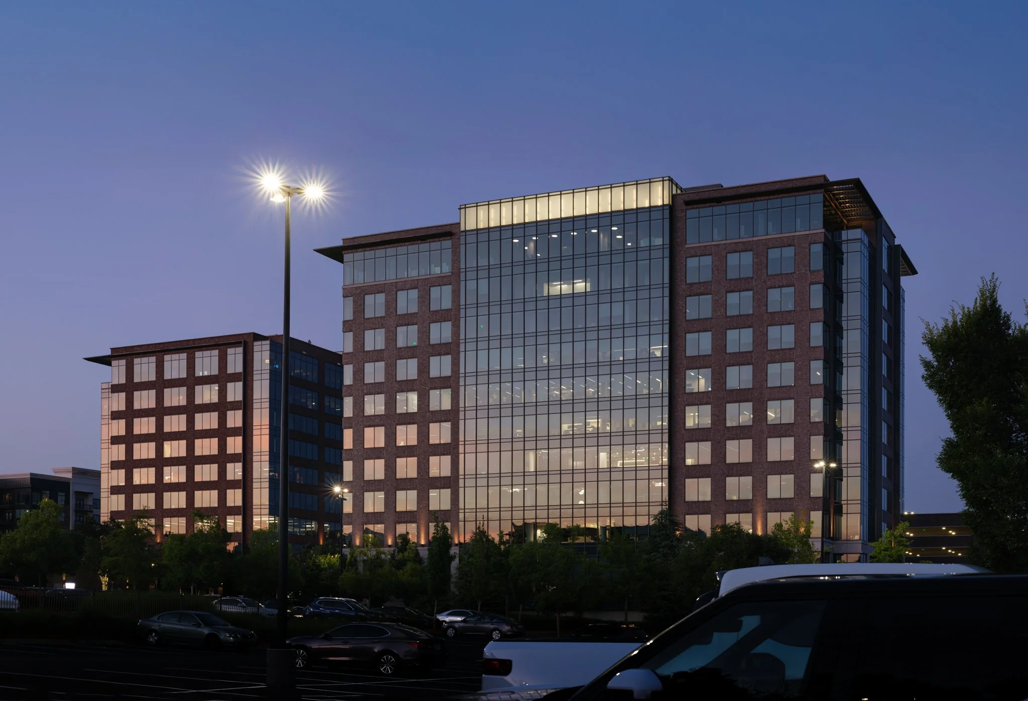 Modern multi-story office building with large glass windows at twilight. | Real Estate Photography | Alpharetta | Milton | Buckhead | Atlanta | Drone | FAA Part 107 | Video | Media | Luxury | Twilight | North Fulton Chamber of Commerce | Avalon | Arc