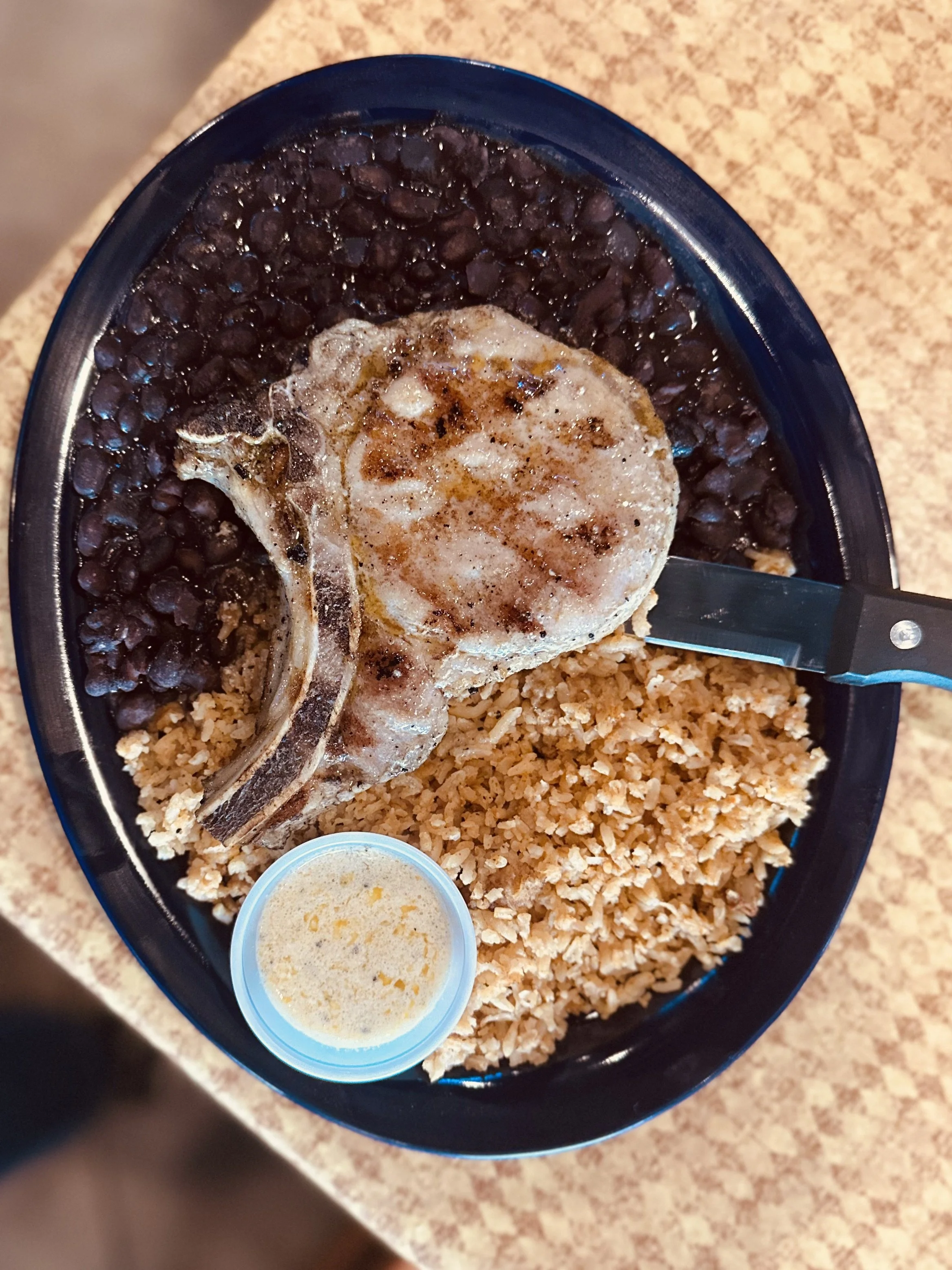 $10.00 menu single mesquite grilled pork chop with spanish rice and black beans. Chardonnay butter sauce for dipping