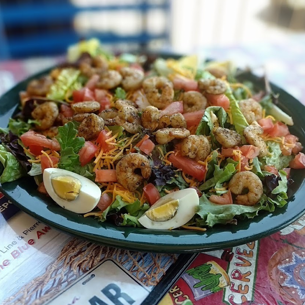 grilled shrimp salad on a bed of mixed greens and hard boiled egg