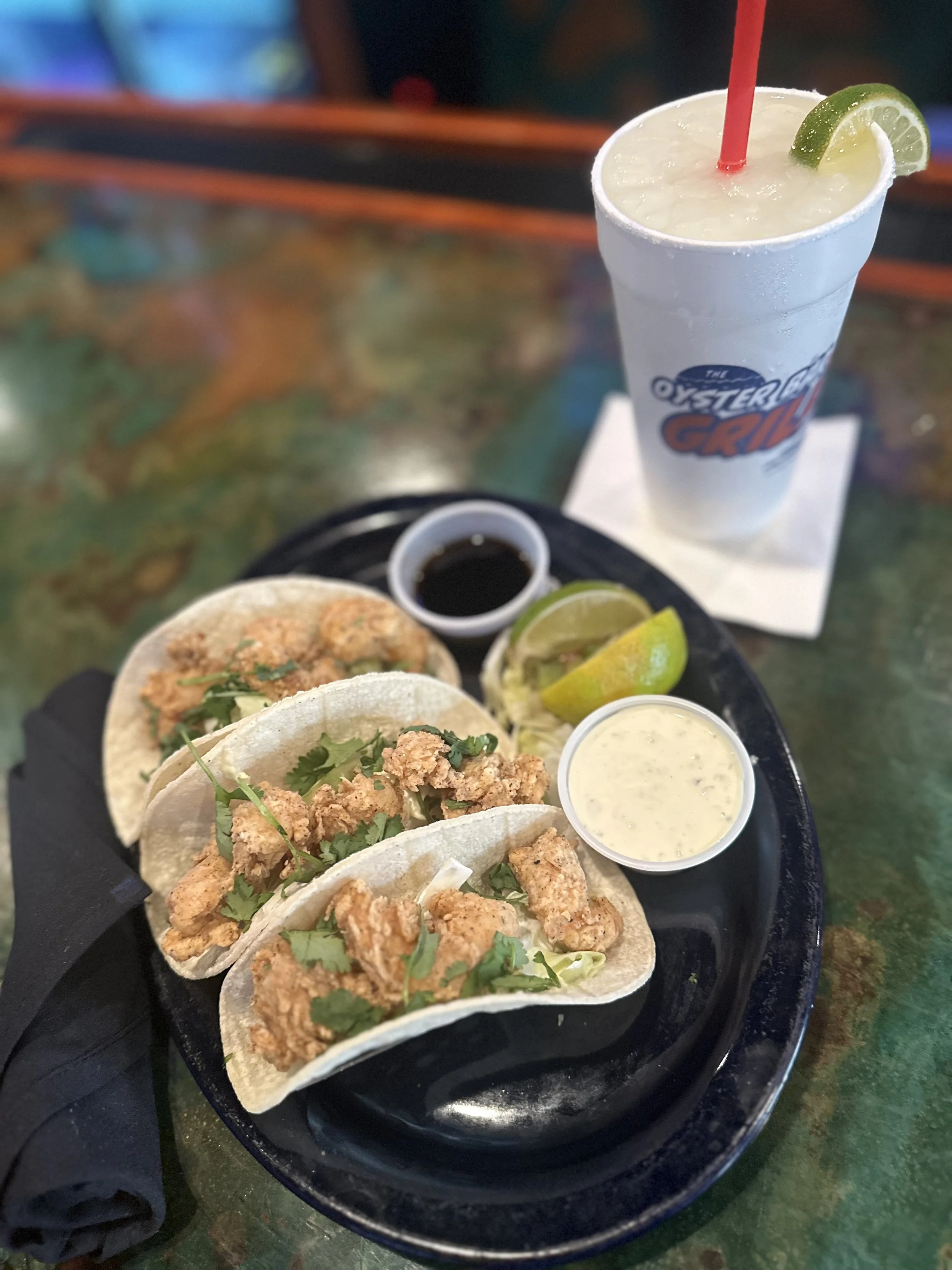 fried shrimp taco on corn tortillas with cliantro and teriyaki dressing and tartar sauce for dressing with fresh lime and frozen margarita
