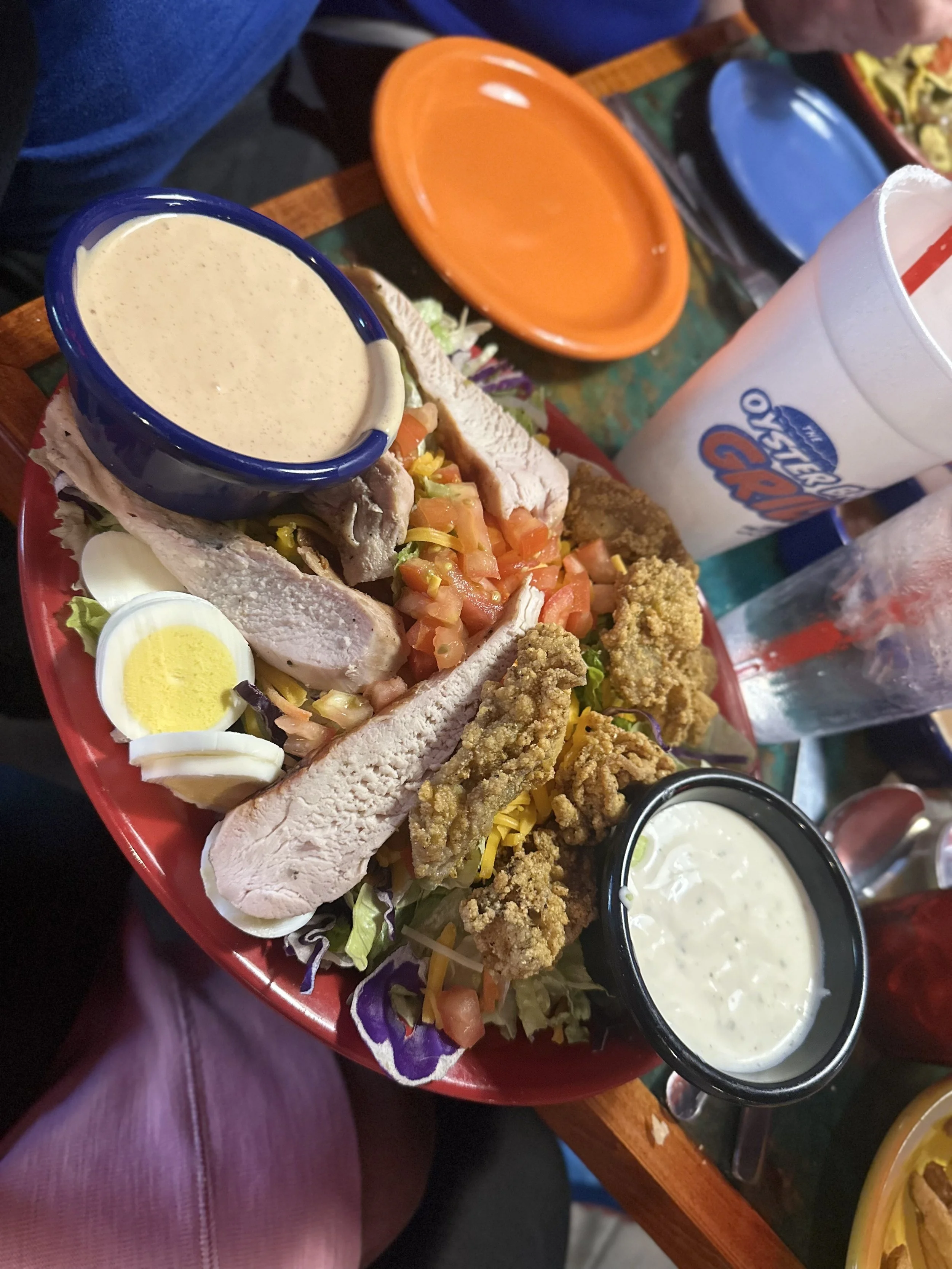 salad with fried oysters and grilled chicken served with blue cheese dressing and house dressing