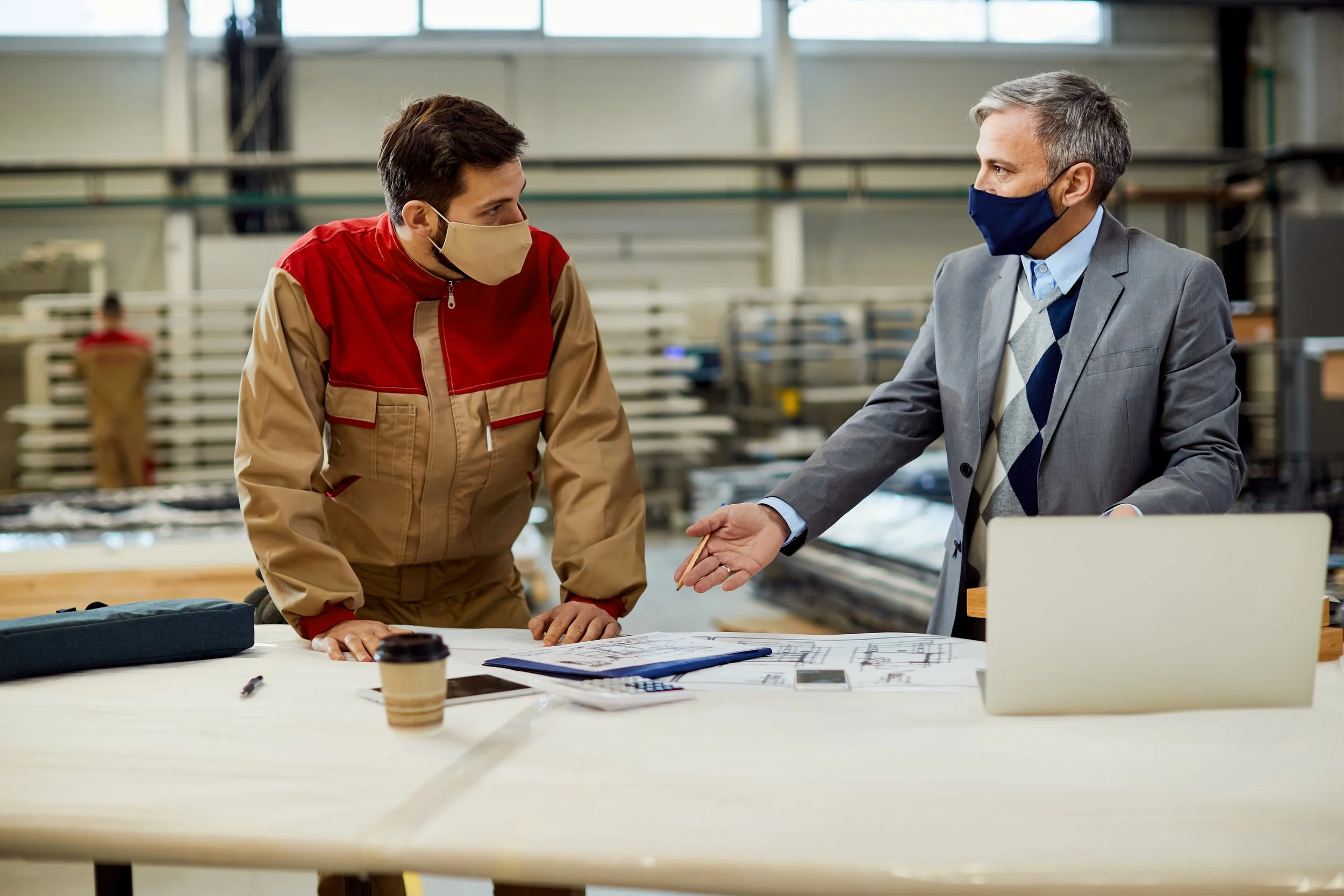 project-manager-talking-carpenter-while-examining-blueprints-workshop.jpg